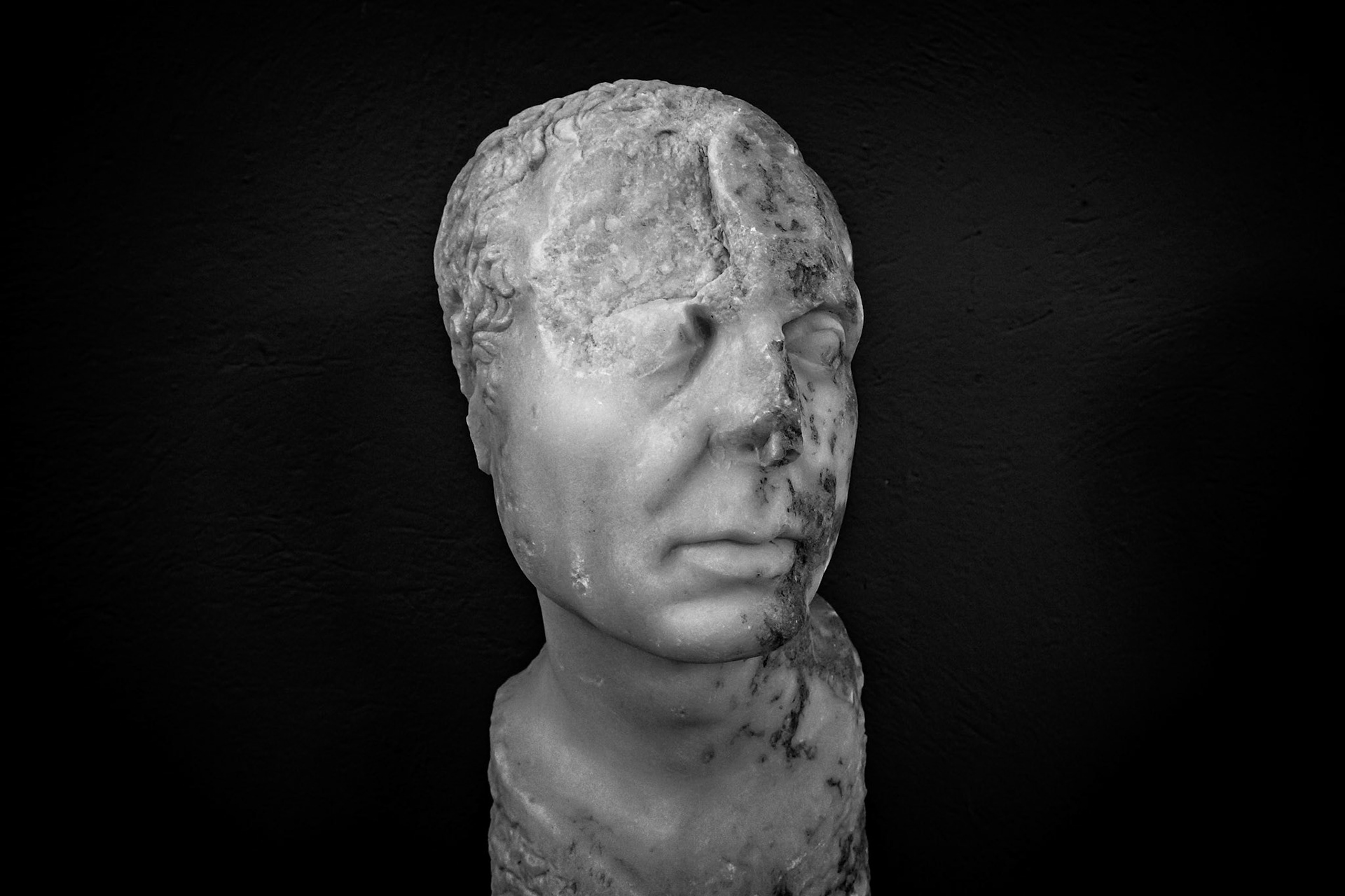 Delos, Greece - May 22nd 2018: A marble head sculpture is displayed, showcasing ancient artistry and the ravages of time on the island of Delos.