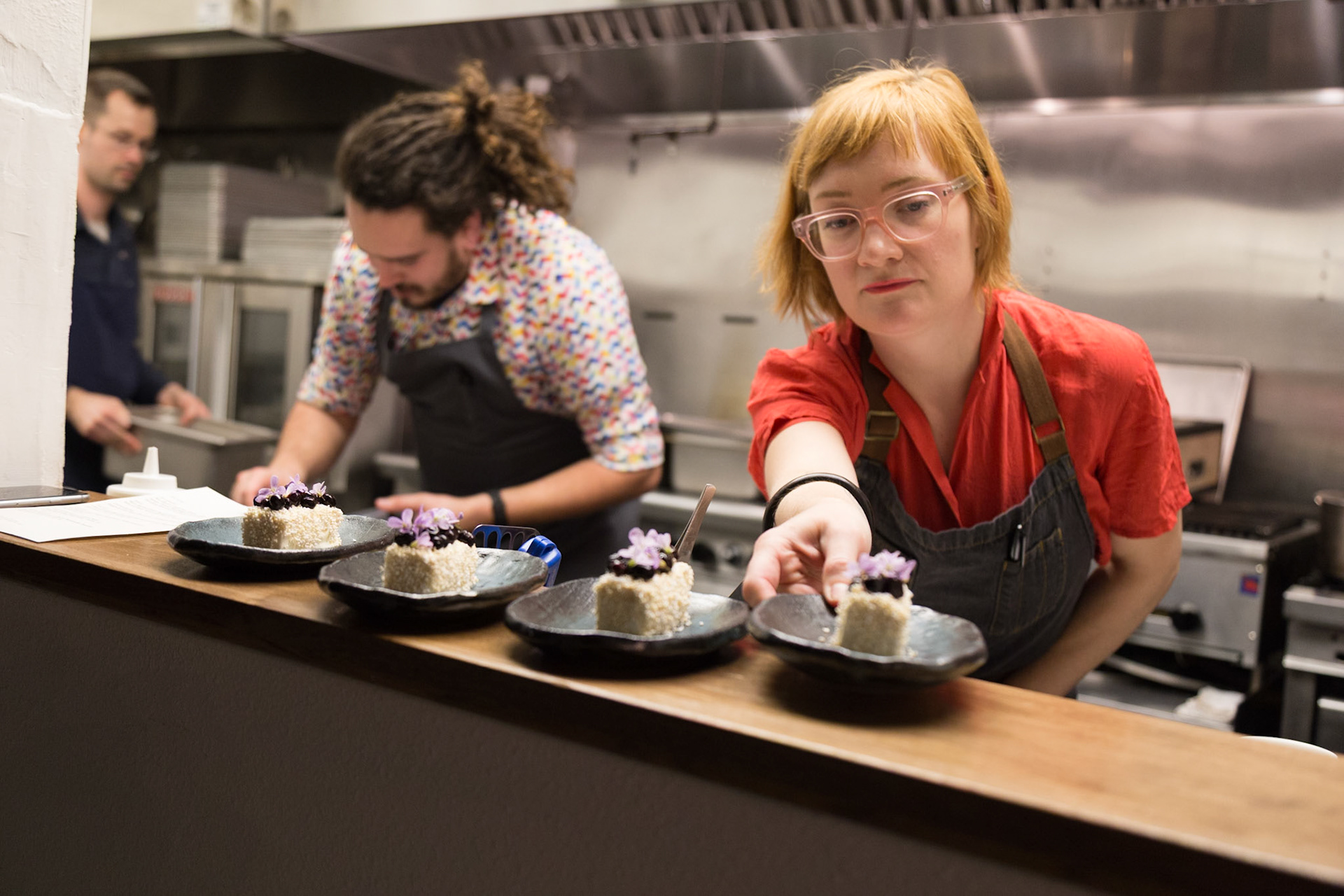 Fog Lark, Portland, Oregon - April 6th 2018: Chefs plating desserts in a professional kitchen, preparing them for service.
