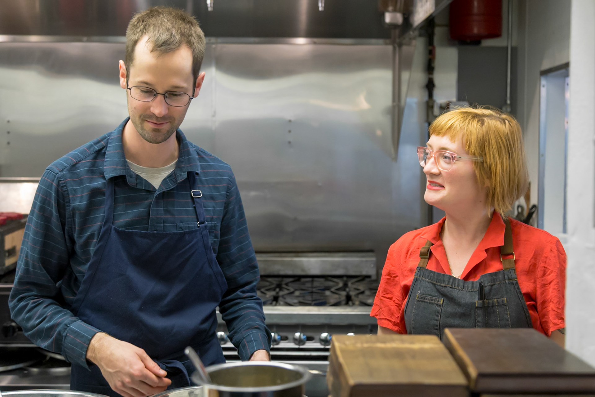 Fog Lark, Portland, Oregon - April 6th 2018: Two chefs in aprons are working in a professional kitchen, likely preparing a meal.