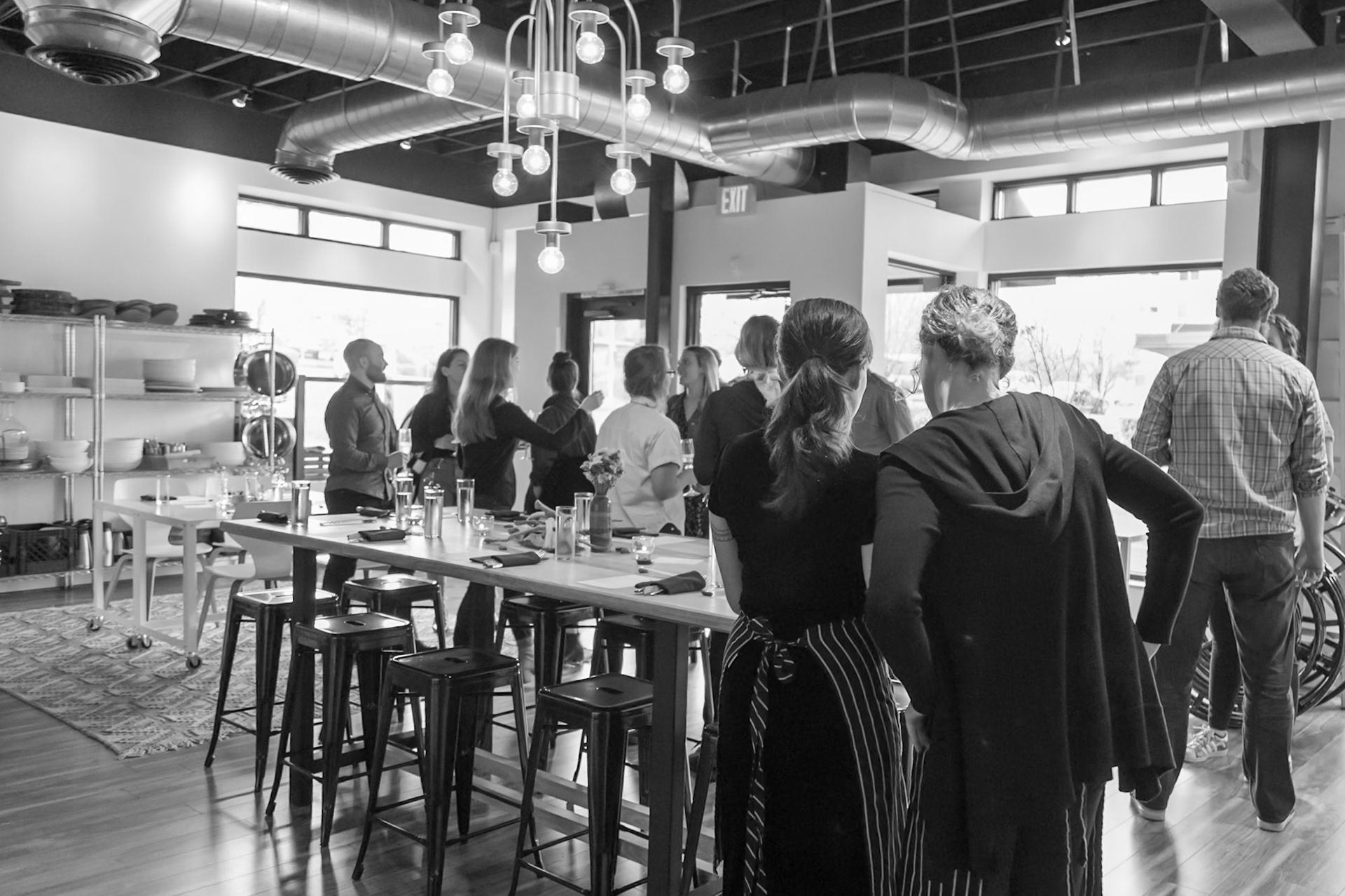 Fog Lark, Portland, Oregon - April 6th 2018: A group gathers around a table, possibly for a cooking class or a catered event, engaging in conversation.