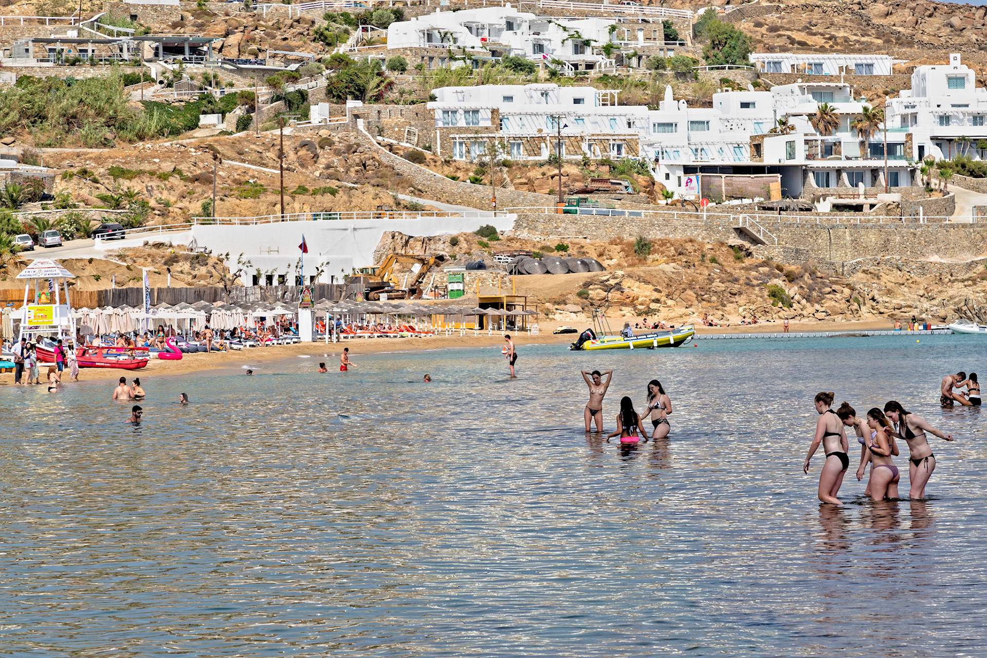 Paradise Beach, Mykonos, Greece - May 24th 2018: People are swimming and enjoying the sun on a beautiful day at the beach.