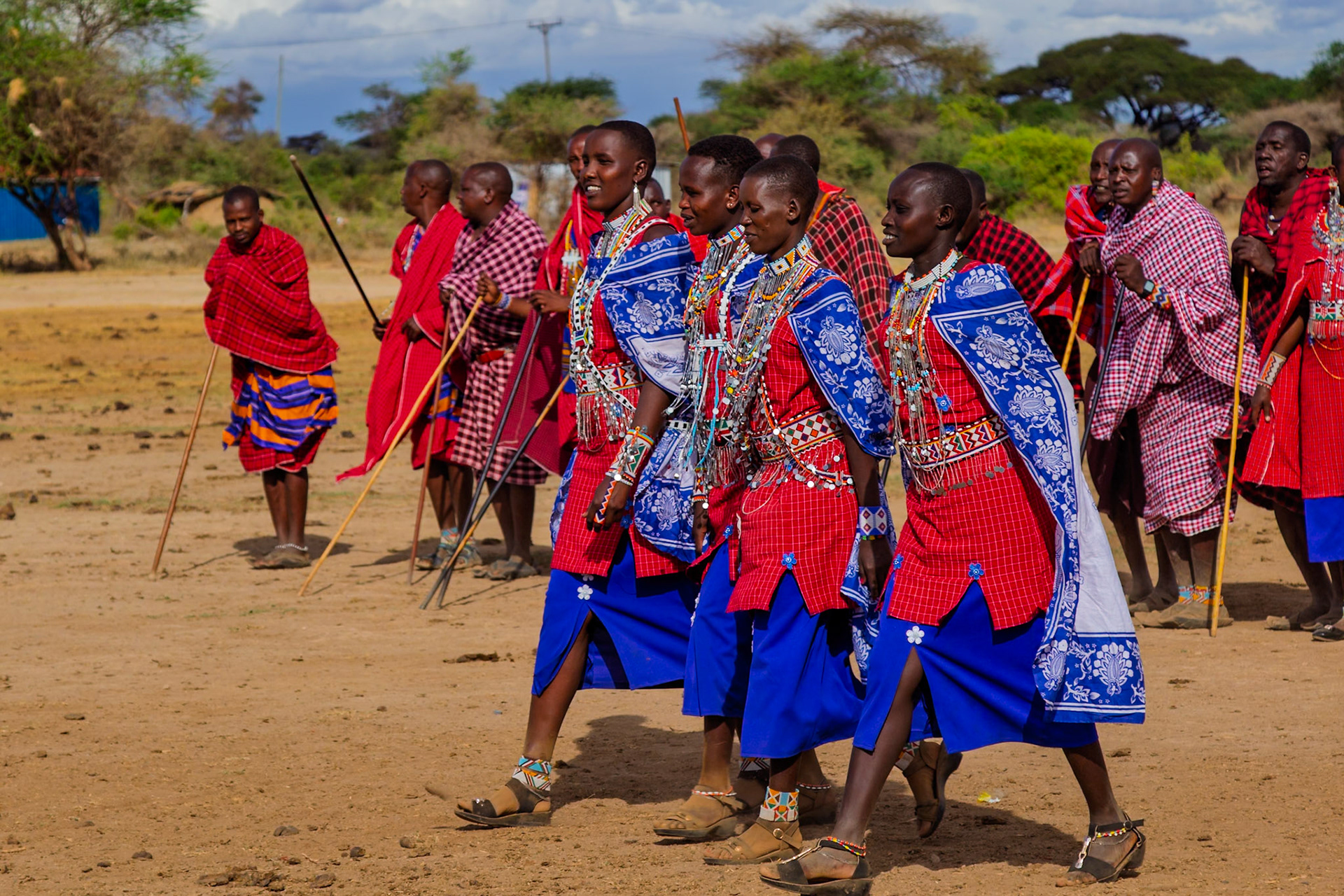 Maasai men in Kenya, adorned in traditional attire, participate in a cultural ceremony in their village.