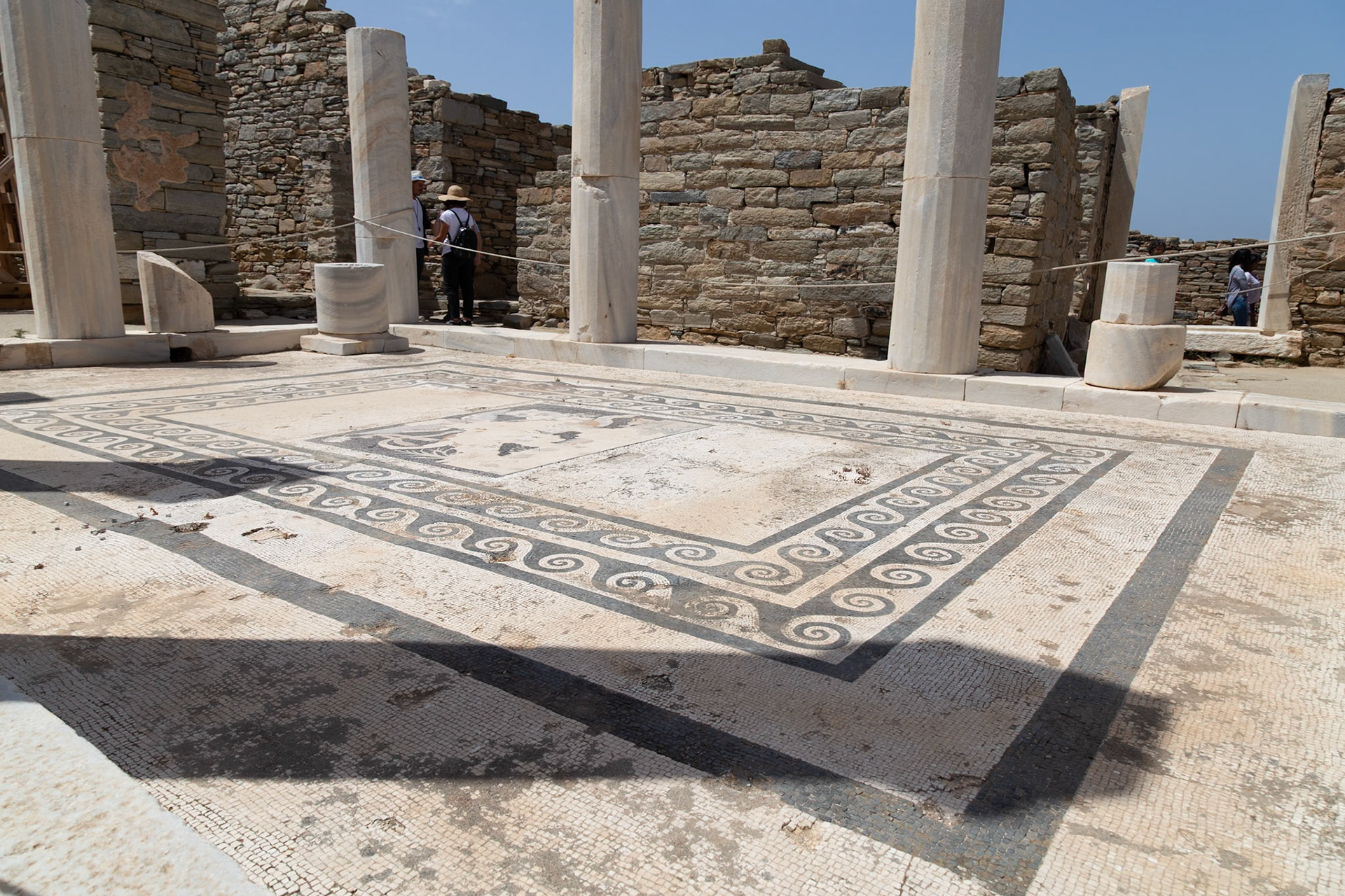 Delos, Greece - May 22nd 2018: Tourists explore the ancient mosaic floors of Delos, Greece. The mosaics are well-preserved and offer a glimpse into the island's rich history.