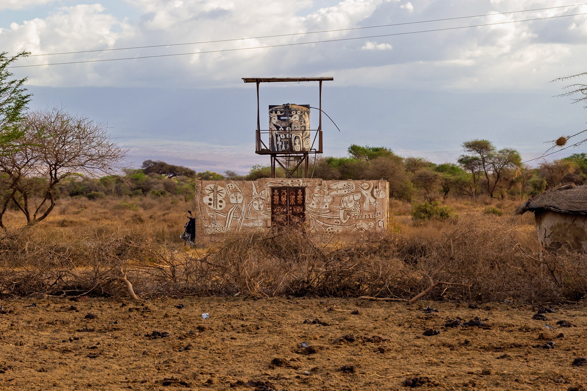 A Maasai village in Kenya features a water tower and painted buildings, reflecting the community's culture and resourcefulness.