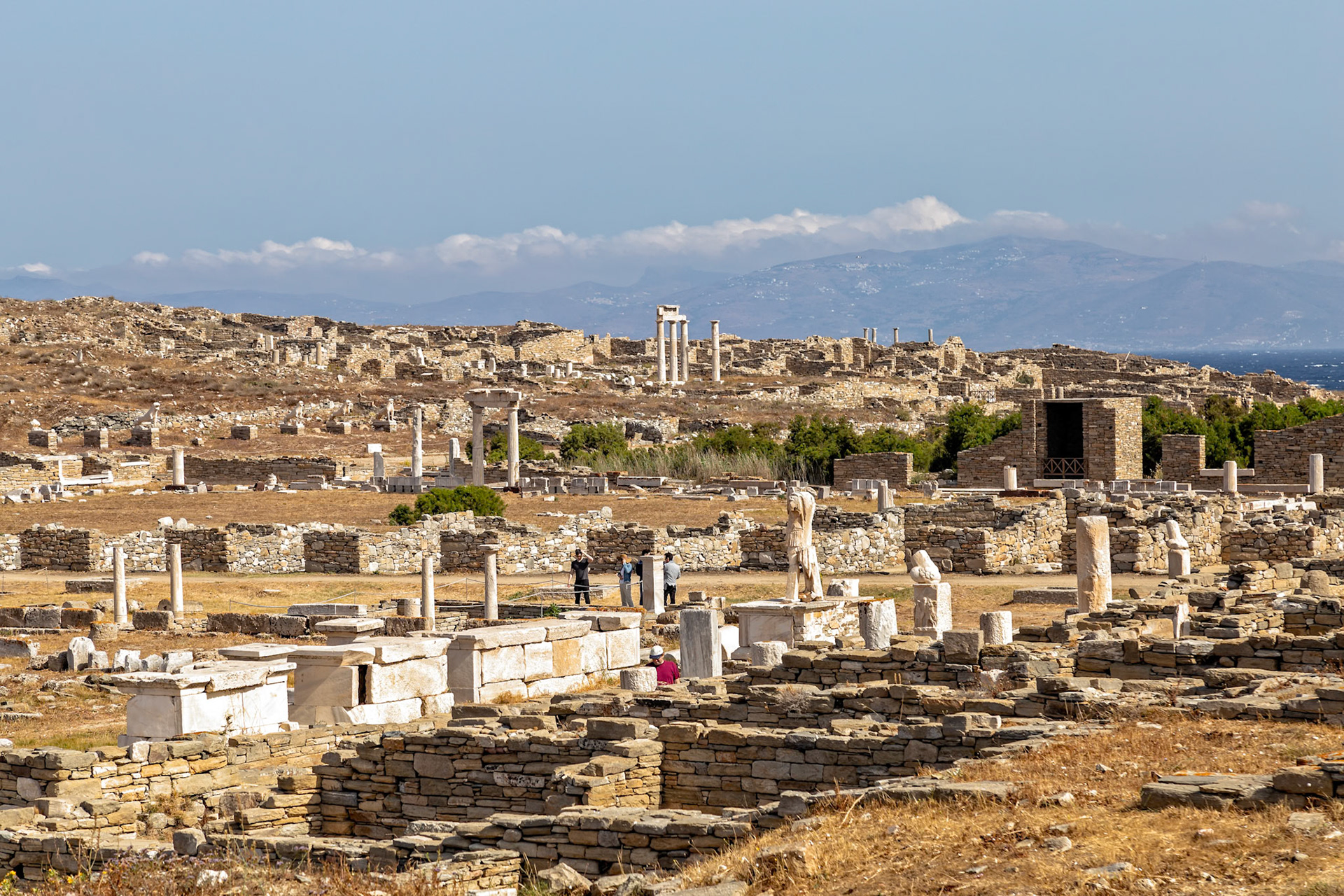 Delos, Greece - May 22nd 2018: Tourists explore the ancient ruins of Delos, a UNESCO World Heritage site, to learn about Greek history and culture.