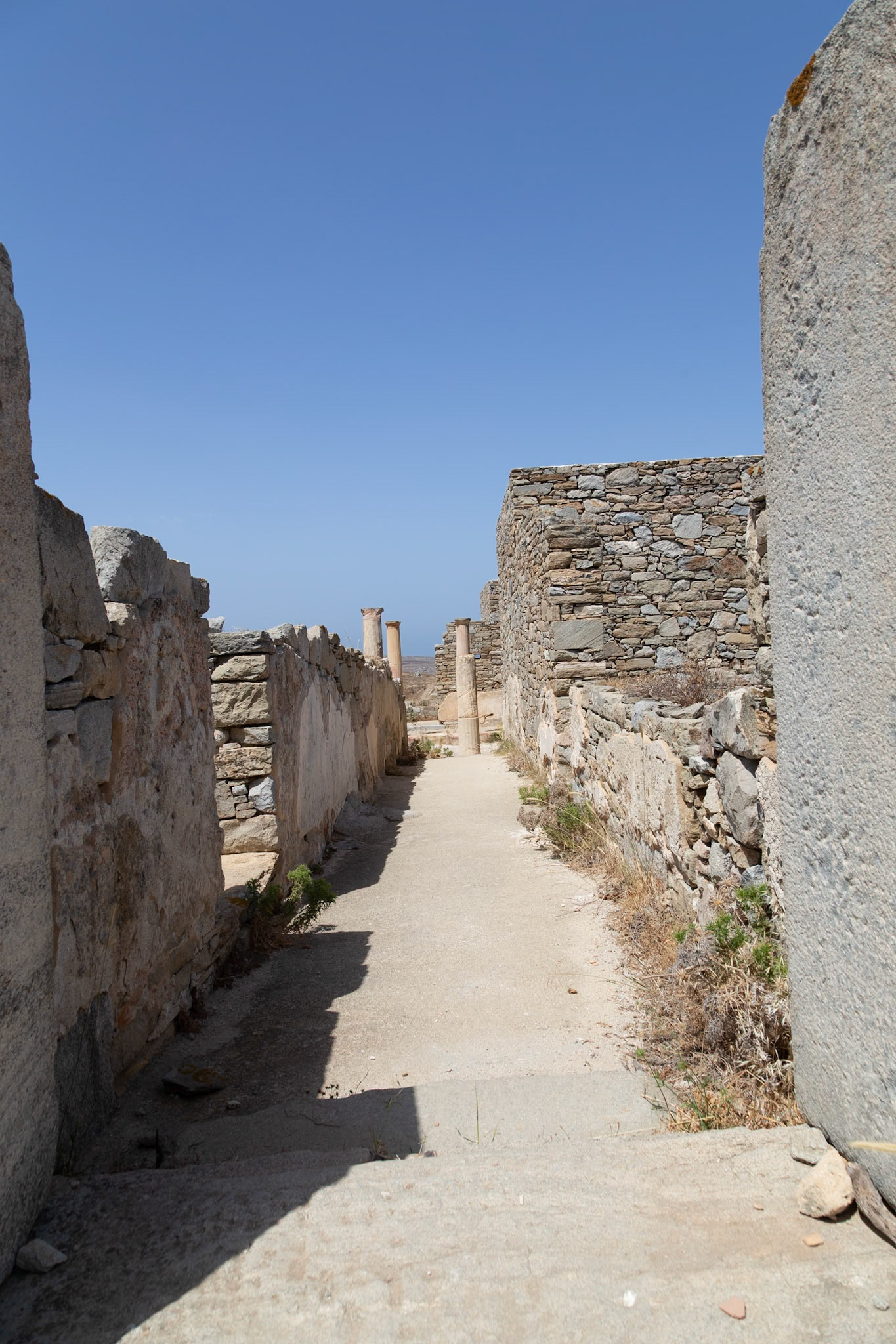 Delos, Greece - May 22nd 2018: A path through the ancient ruins of Delos. The ruins are preserved to show the ancient Greek architecture and history.