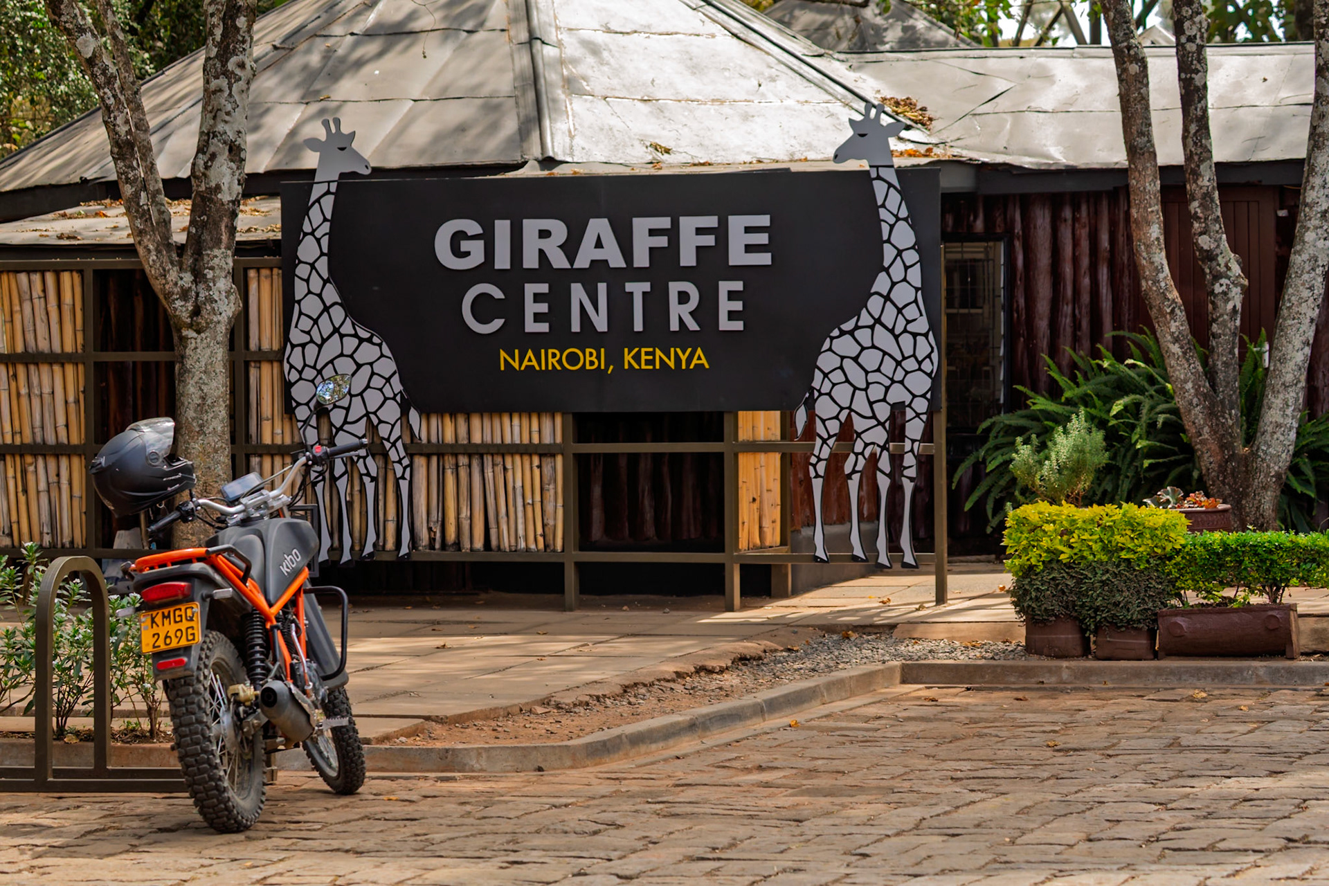A Kibo motorcycle is parked at the Giraffe Center in Nairobi, Kenya. Visitors come to learn about and feed the giraffes.