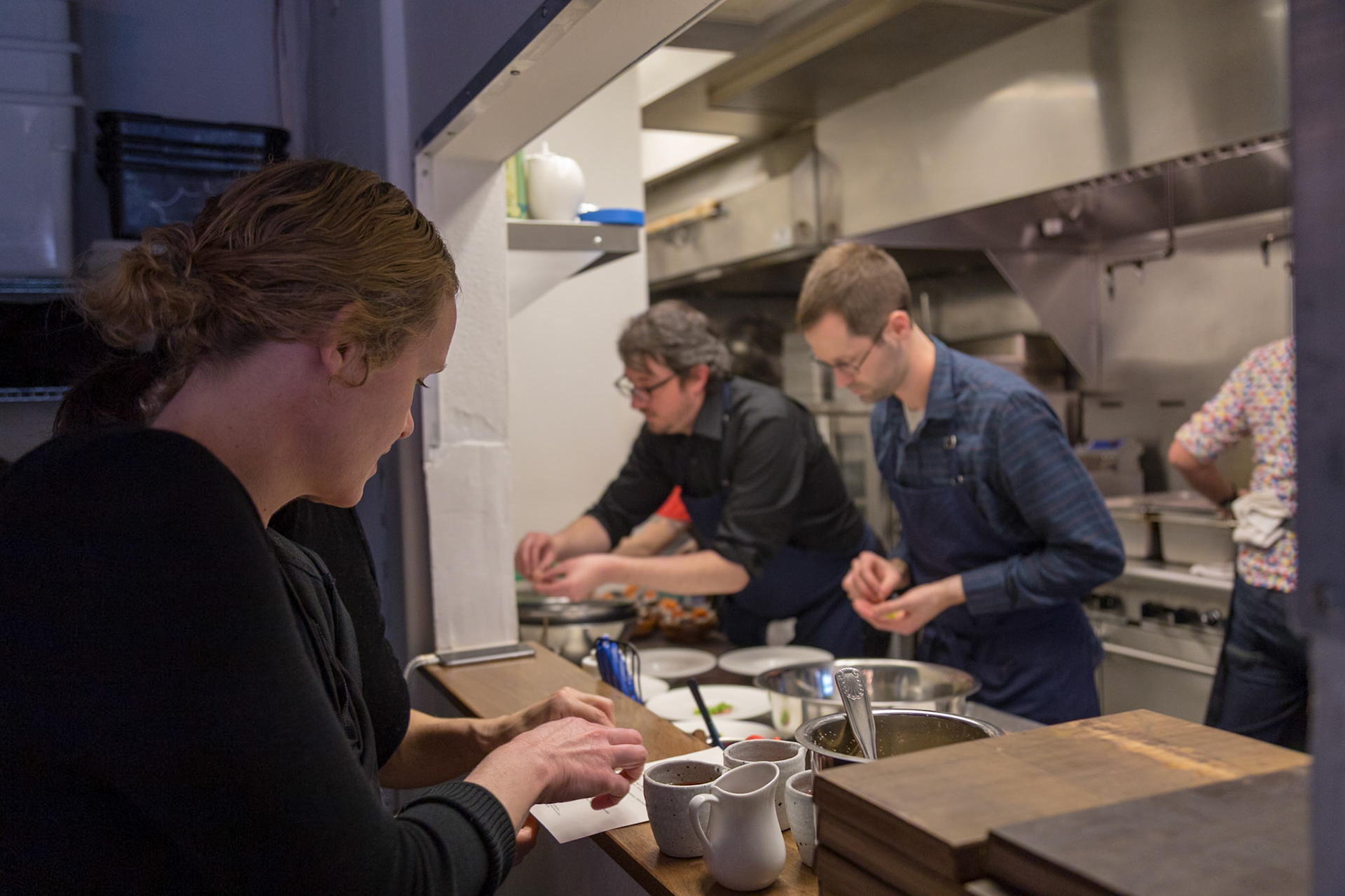Fog Lark, Portland, Oregon - April 6th 2018: Chefs prep food in a busy kitchen, ensuring quality and presentation for diners.