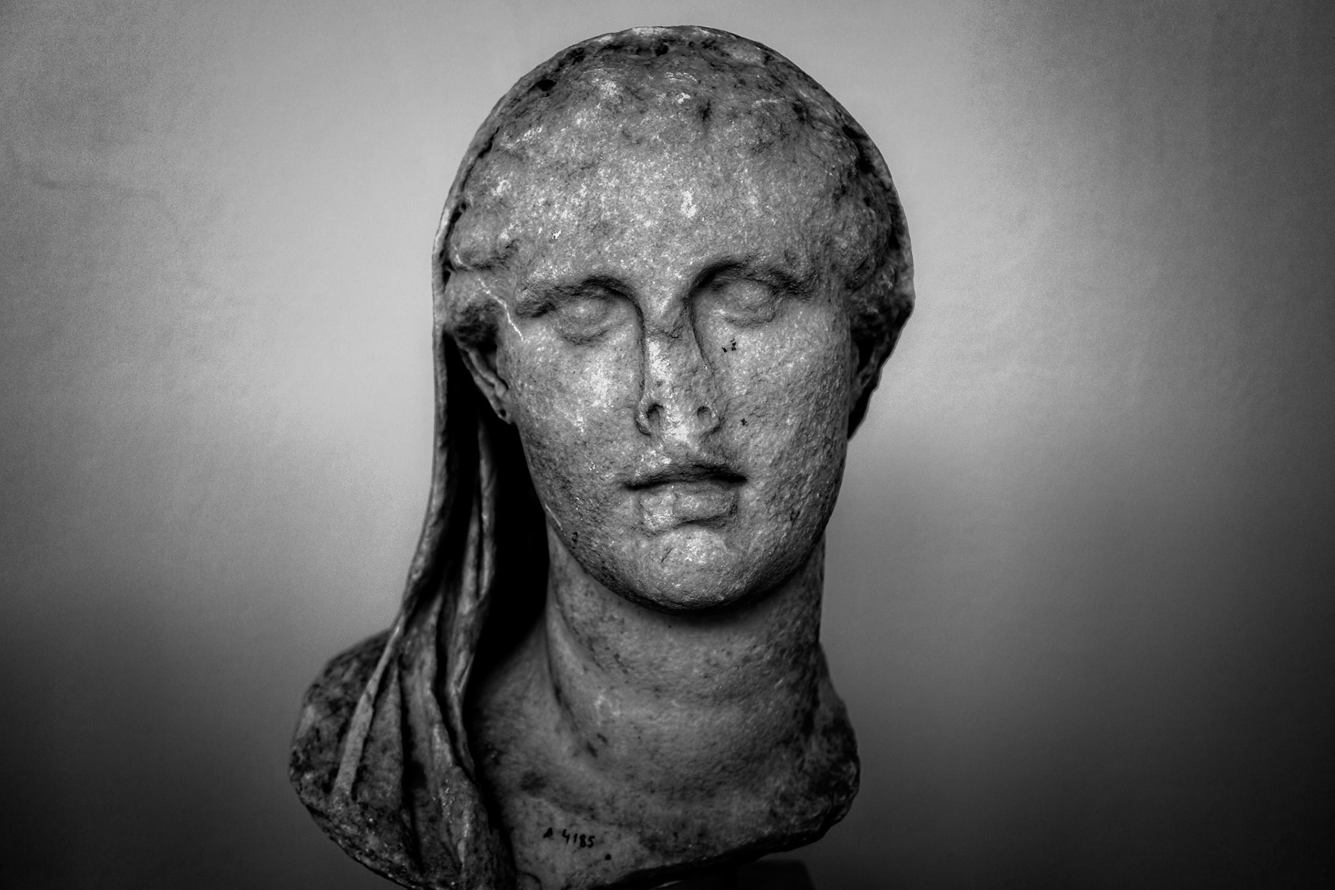 Delos, Greece - May 22nd 2018: A bust of a woman with her hair pulled back, possibly a goddess, stands in a museum. It is a relic of the past.