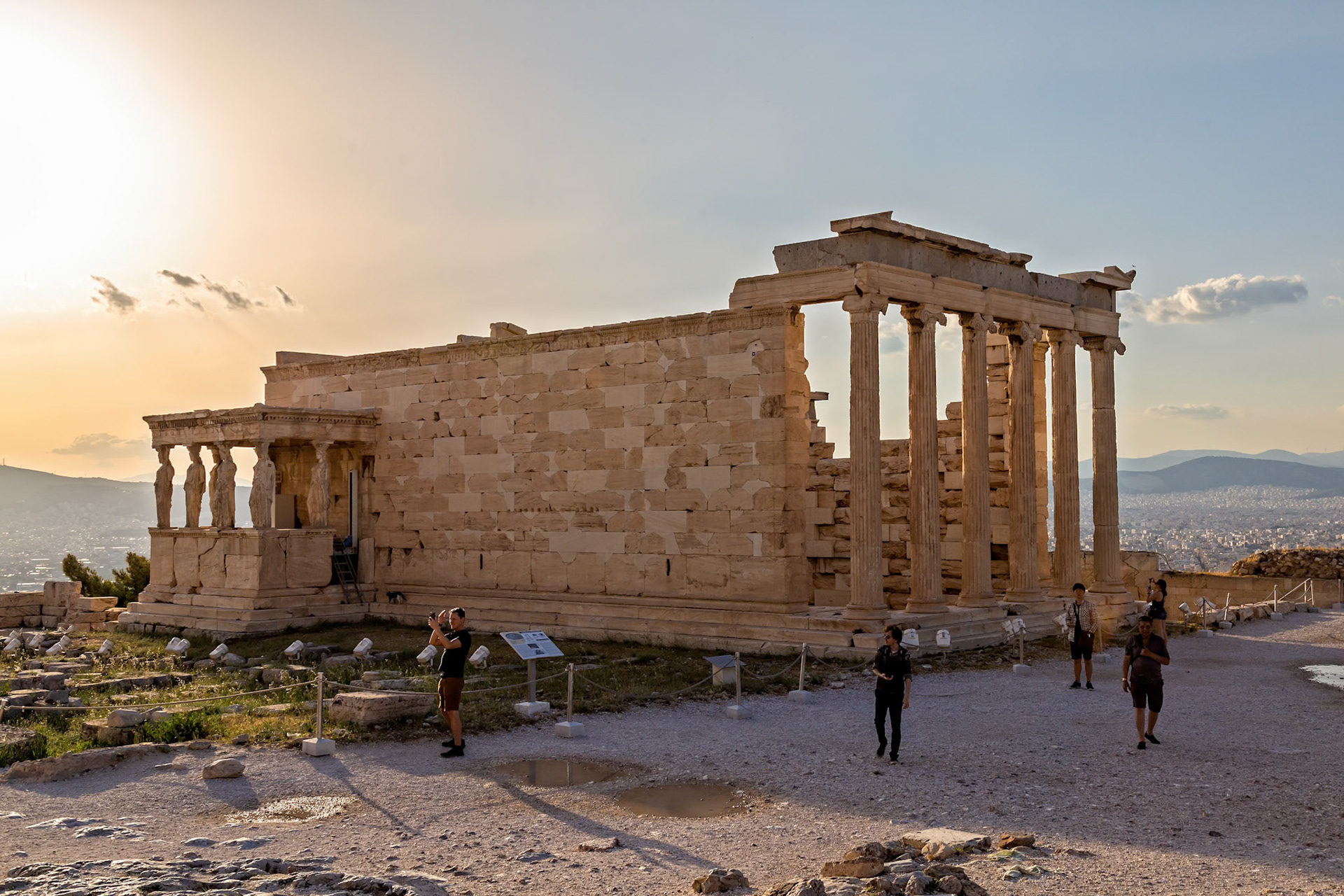 Acropolis, Athens, Greece - May 23rd 2018: Tourists visit the Erechtheion, an ancient Greek temple, to admire its architecture and learn about its history.