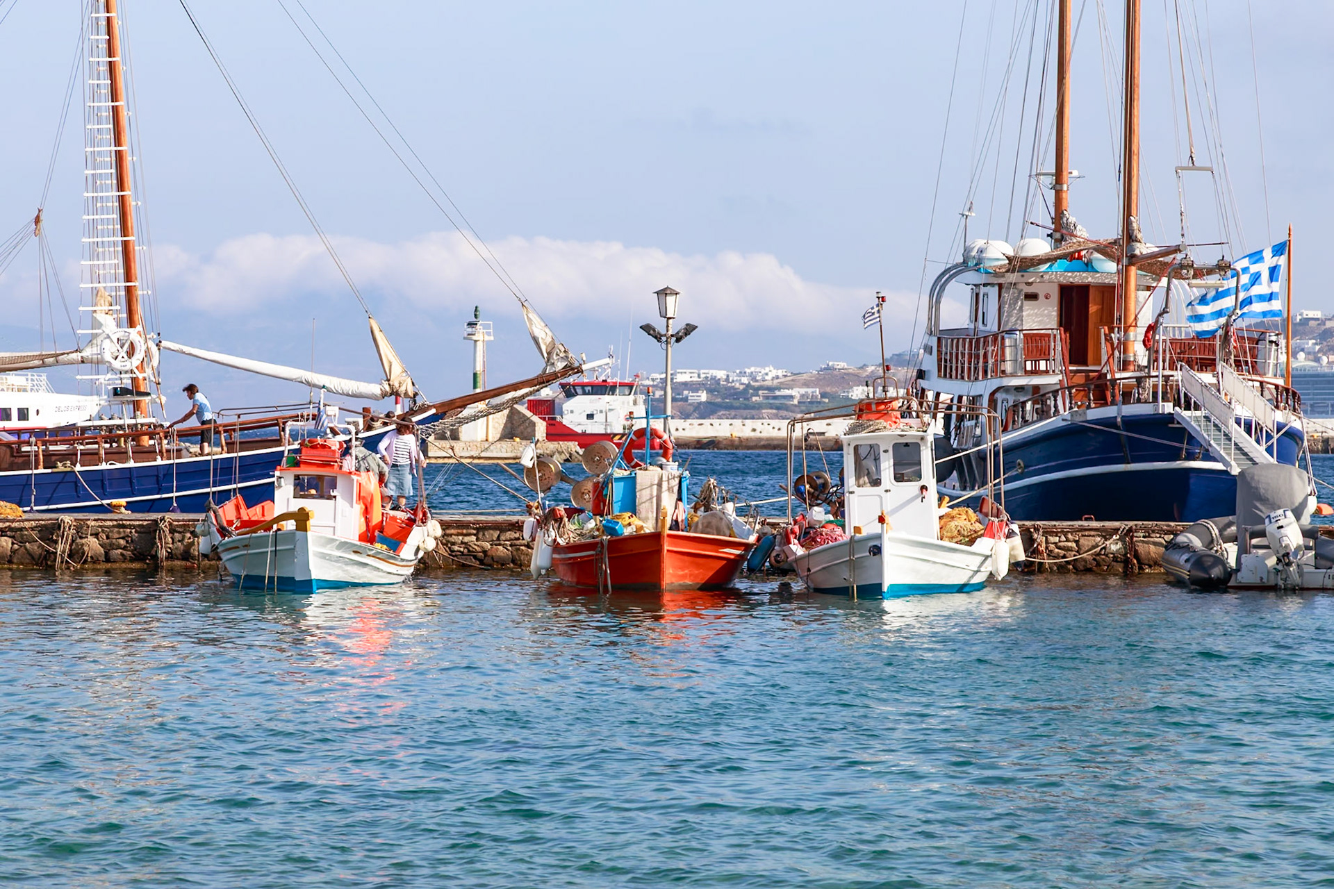 Mykonos, Greece - May 23rd 2018: Fishing boats docked in the harbor, likely preparing for the day's catch or returning with their haul.