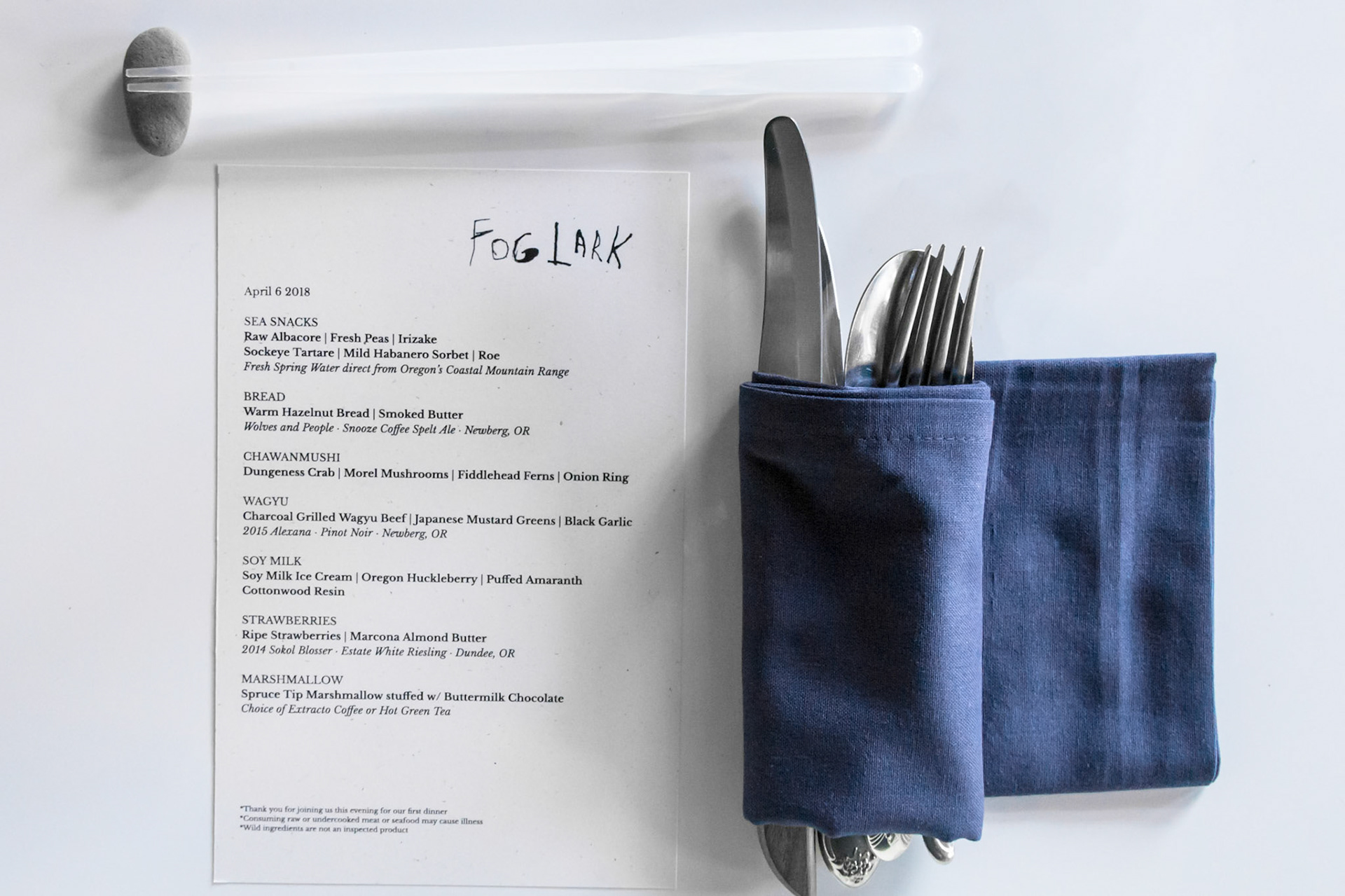Fog Lark, Portland, Oregon - April 6th 2018: A menu from Fog Lark restaurant is displayed next to silverware wrapped in a blue napkin.
