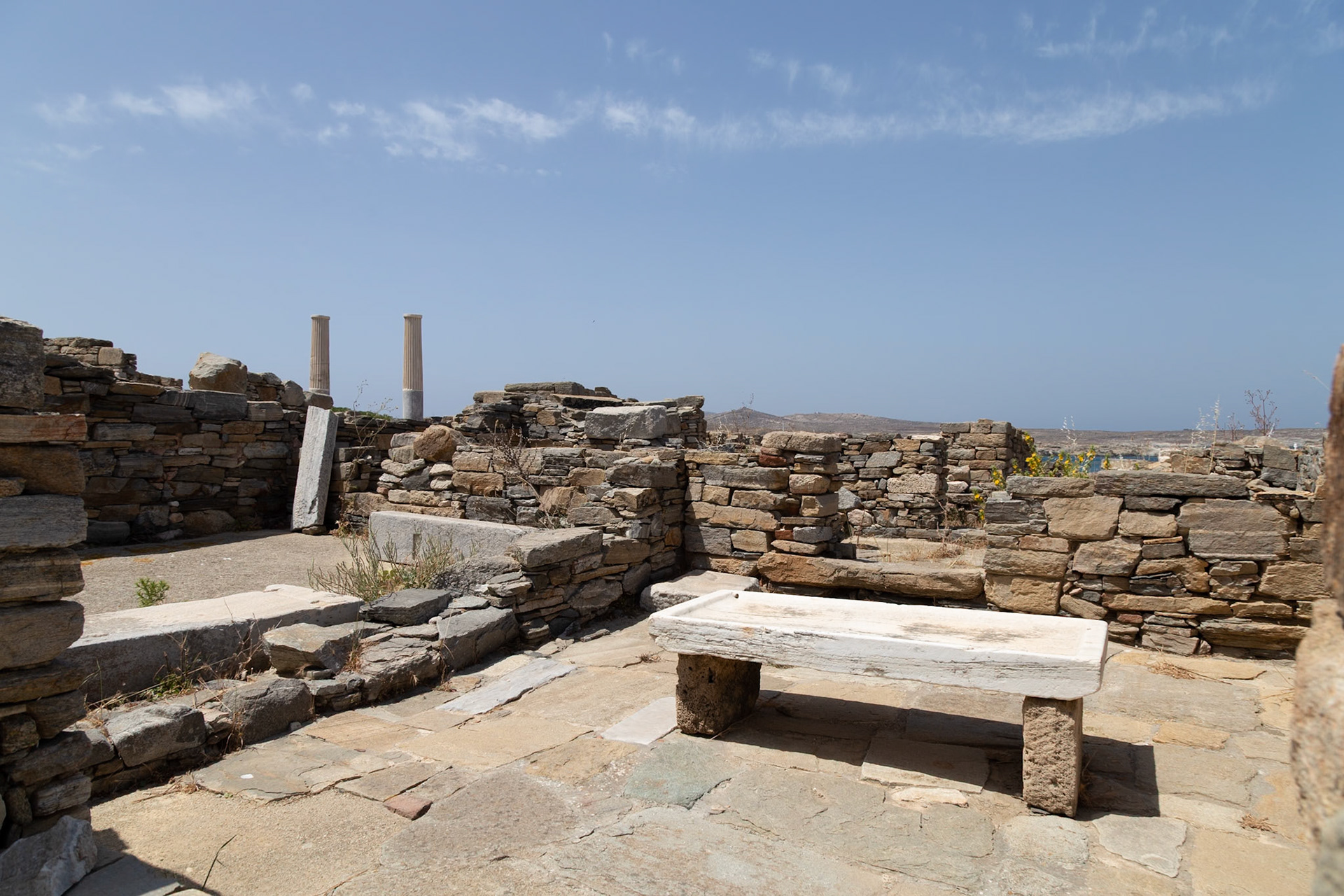 Delos, Greece - May 22nd 2018: Ruins of ancient structures stand against a clear sky. These remnants offer a glimpse into the island's rich history and cultural significance.