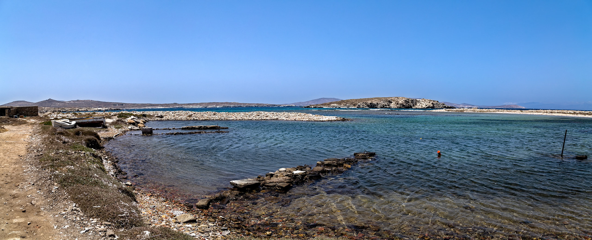Delos, Greece - May 22nd 2018: A scenic view of the coastline with clear blue waters, rocky shores, and distant islands, showcasing the natural beauty of Delos.