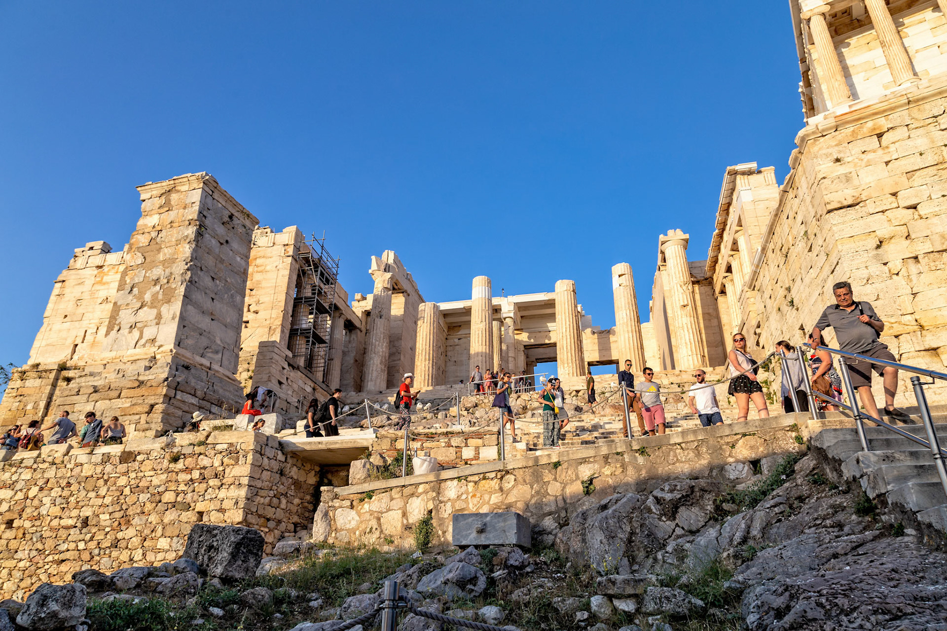 Acropolis, Athens, Greece - May 23rd 2018: Tourists explore the ancient ruins of the Acropolis, walking up the steps to view the historic site.