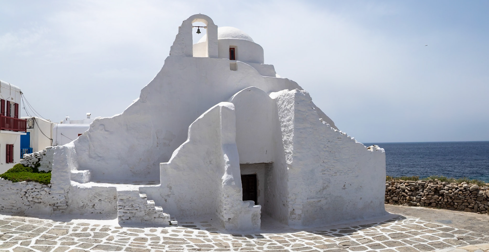 Mykonos, Greece - May 23rd 2018: A whitewashed church, Panagia Paraportiani, stands as a landmark, showcasing Cycladic architecture by the sea.