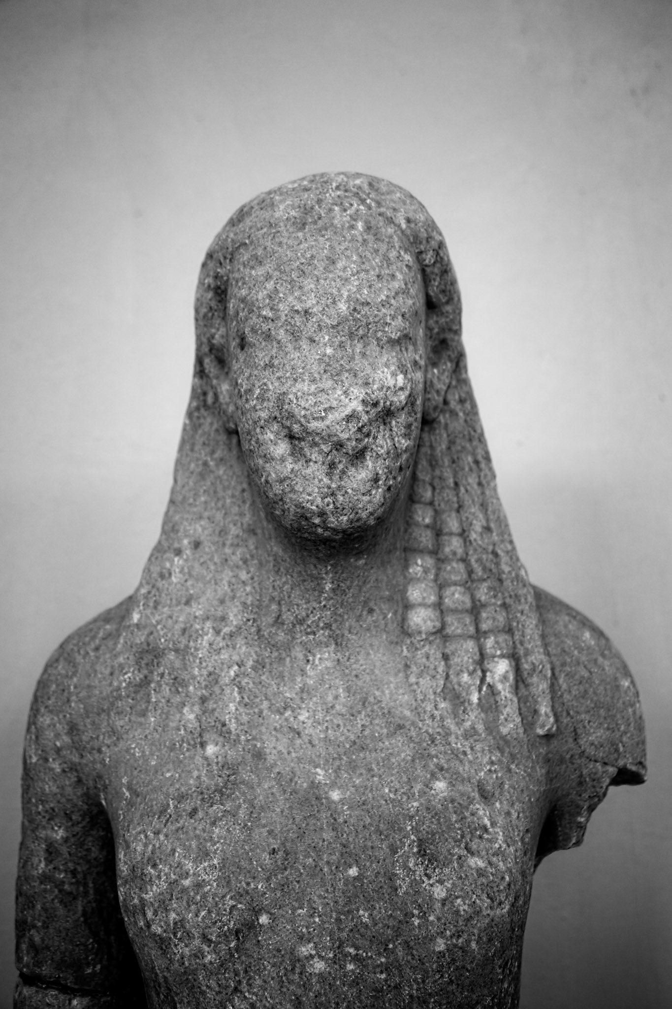 Delos, Greece - May 22nd 2018: A weathered, headless statue stands, its features eroded by time, a silent testament to the island's rich history and ancient past.