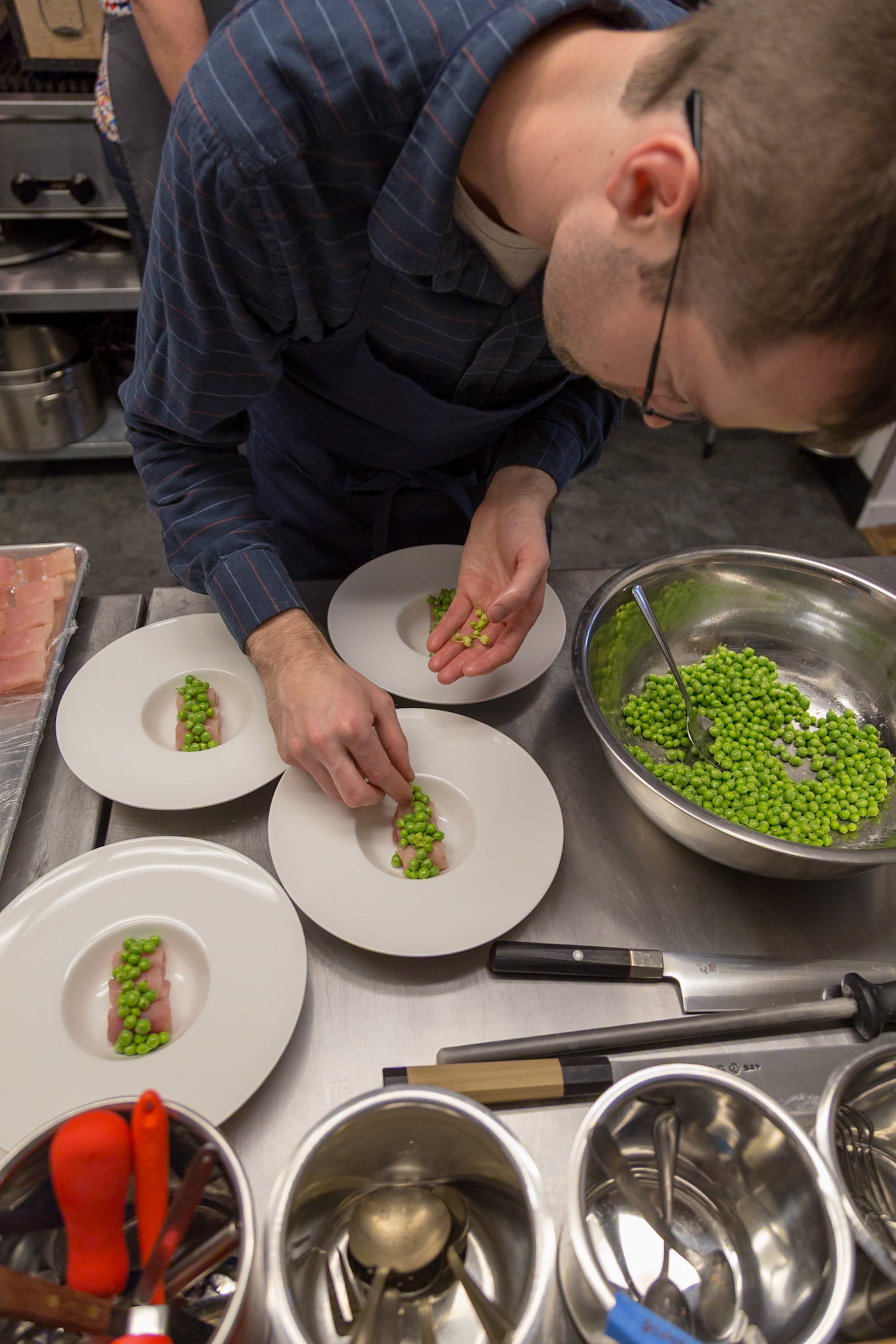 Fog Lark, Portland, Oregon - April 6th 2018: A chef meticulously plates a dish with tuna and peas, ensuring a perfect presentation.