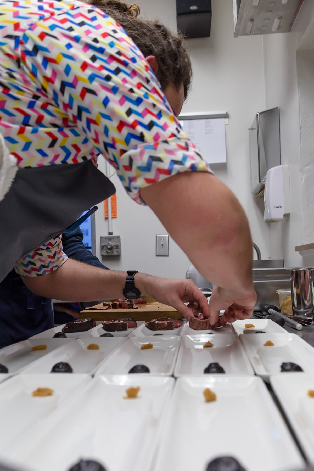 Fog Lark, Portland, Oregon - April 6th 2018: A chef plates sliced steak with sauces, ensuring each dish is perfect for service.