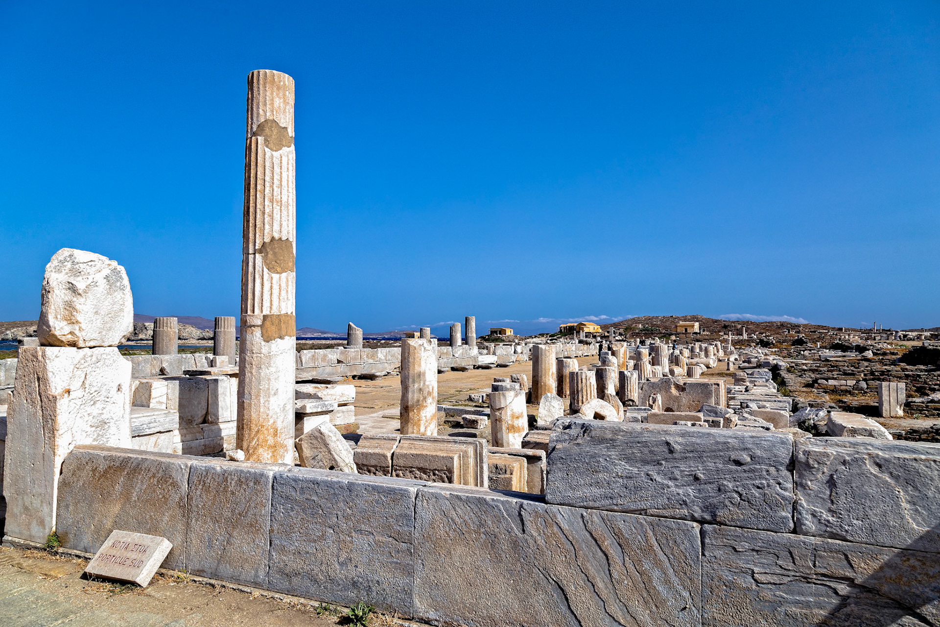Delos, Greece - May 22nd 2018: Ruins of the ancient city of Delos, a UNESCO World Heritage site, are preserved for visitors to explore and learn about Greek history.