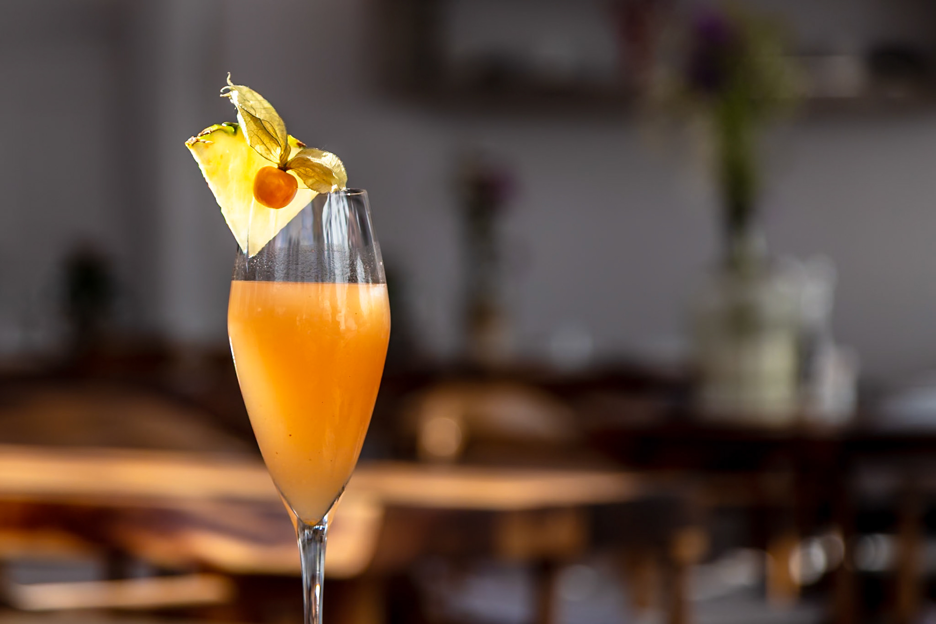 Mykonos, Greece - May 22nd 2018: A tropical cocktail is garnished with pineapple and a physalis, ready to be enjoyed at a local restaurant.