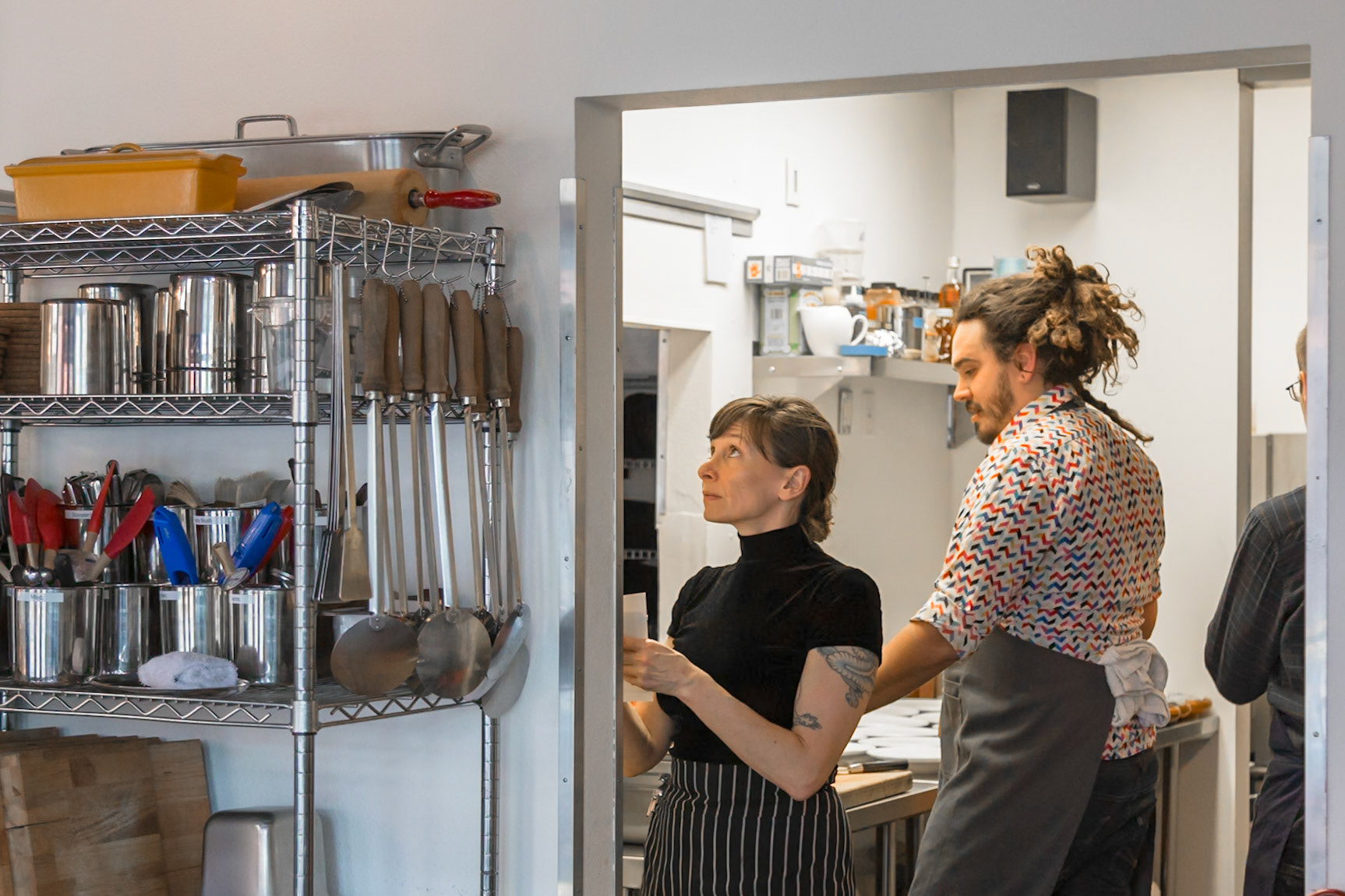 Fog Lark, Portland, Oregon - April 6th 2018: Two chefs in aprons are looking at a list in the kitchen, possibly planning the day's menu.