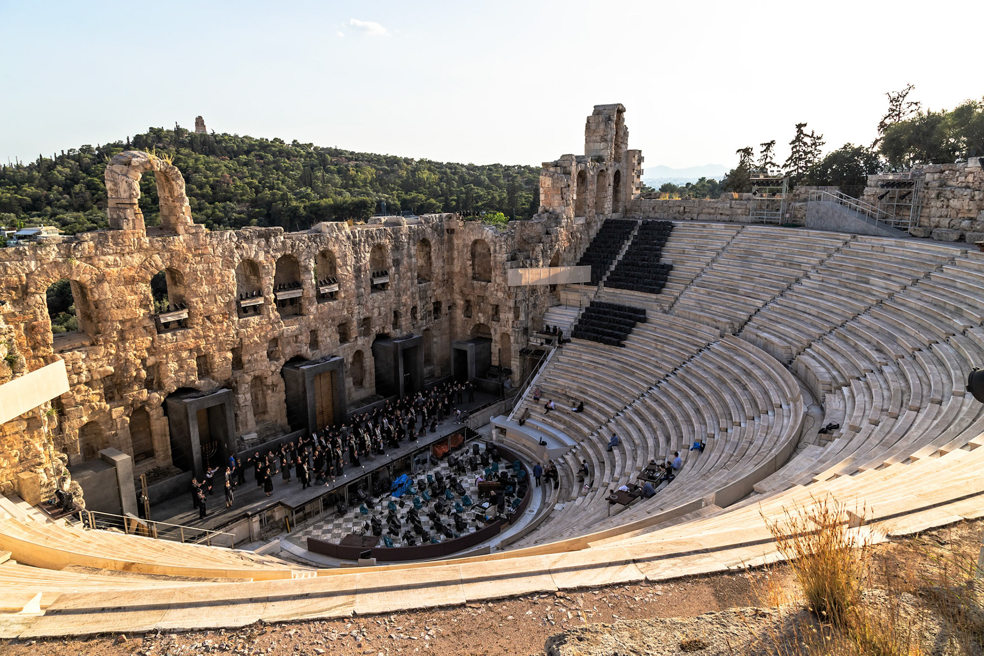 Acropolis, Athens, Greece - May 23rd 2018: An orchestra performs at the Odeon of Herodes Atticus, an ancient Roman theater, for an audience of tourists.