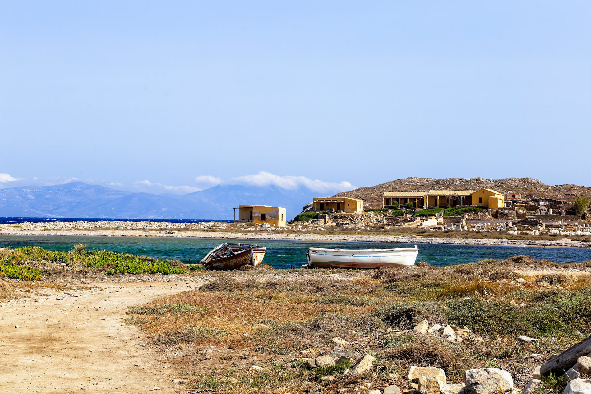 Delos, Greece - May 22nd 2018: Two boats sit on the shore of Delos, an island known for its ancient ruins and mythological significance as the birthplace of Apollo.