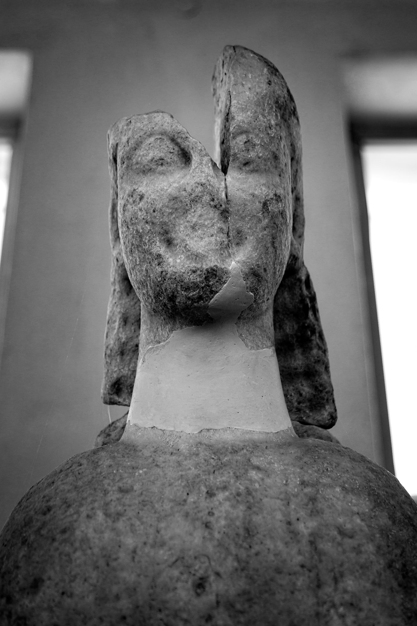 Delos, Greece - May 22nd 2018: A weathered statue stands, its face cracked, yet it embodies the enduring legacy of ancient Greek artistry and cultural heritage.