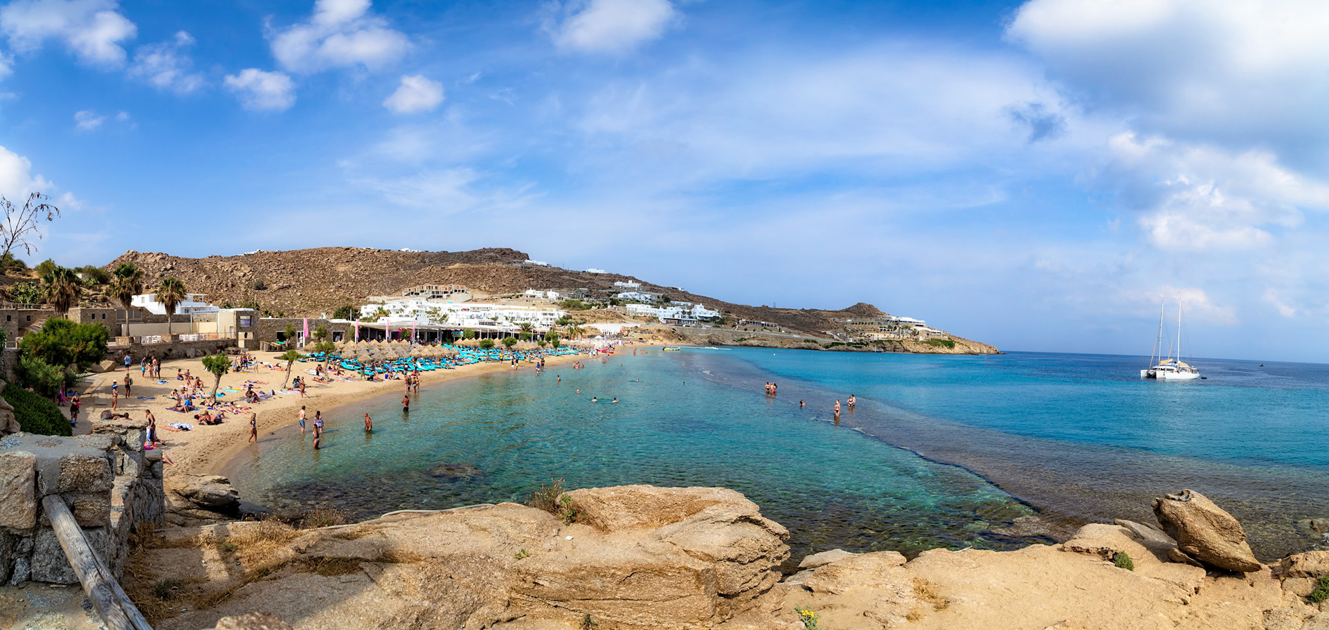 Paradise Beach, Mykonos, Greece - May 24th 2018: People enjoy swimming and sunbathing on a sunny day at the popular beach resort.