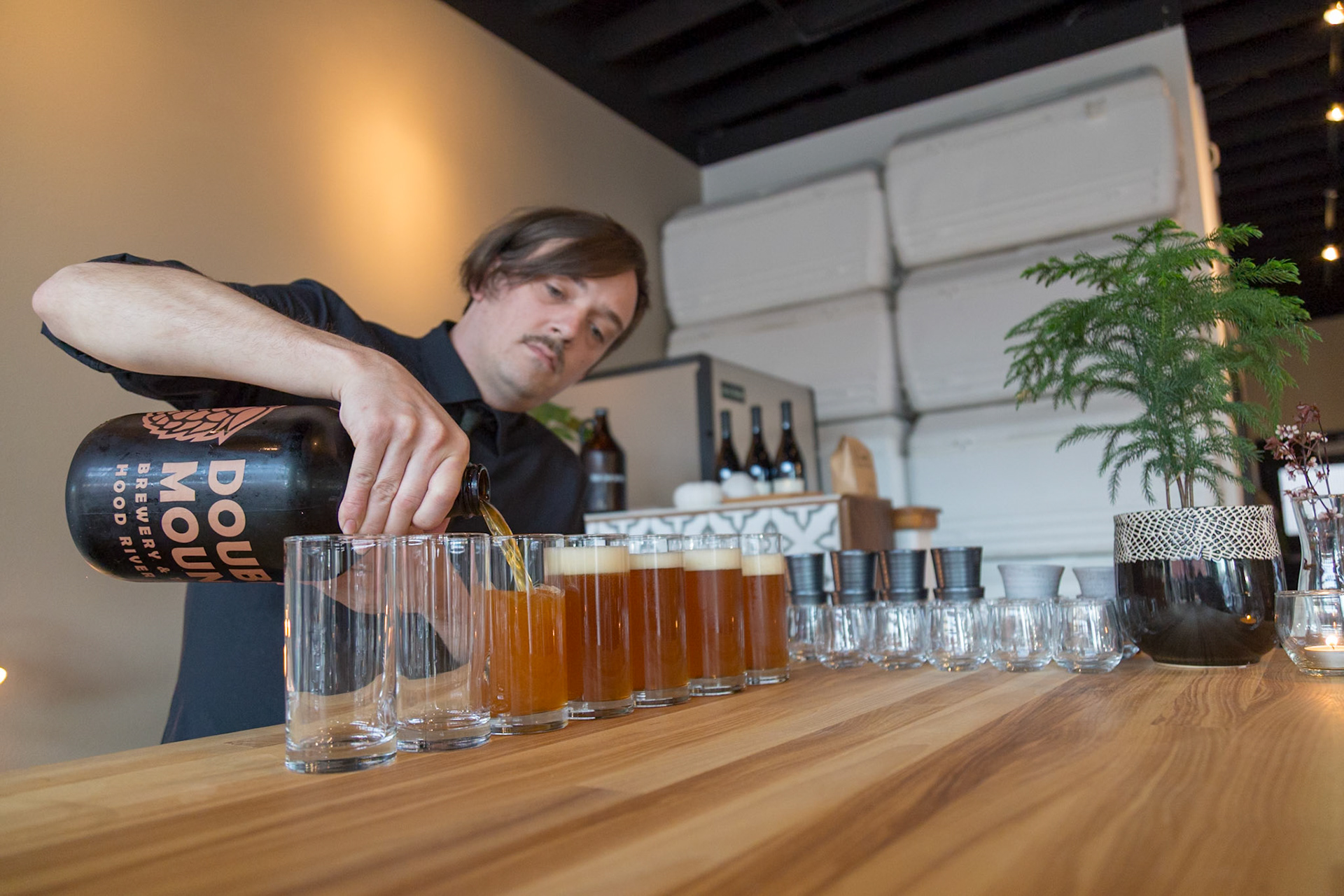 Fog Lark, Portland, Oregon - April 6th 2018: A bartender pours Double Mountain Brewery beer into glasses for a tasting flight.