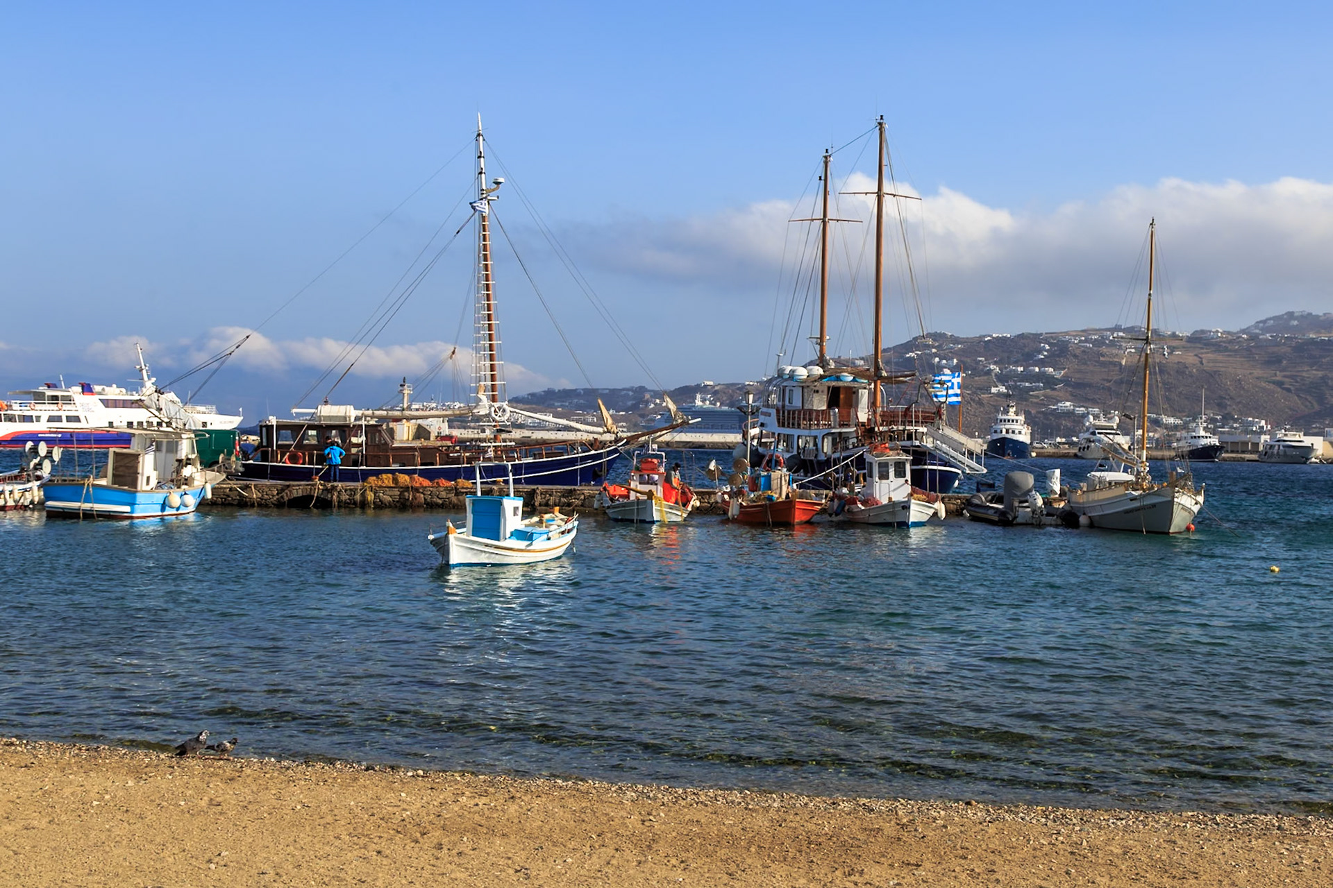 Mykonos, Greece - May 23rd 2018: Fishing boats and yachts are docked in the harbor, ready for tourists to explore the Aegean Sea.