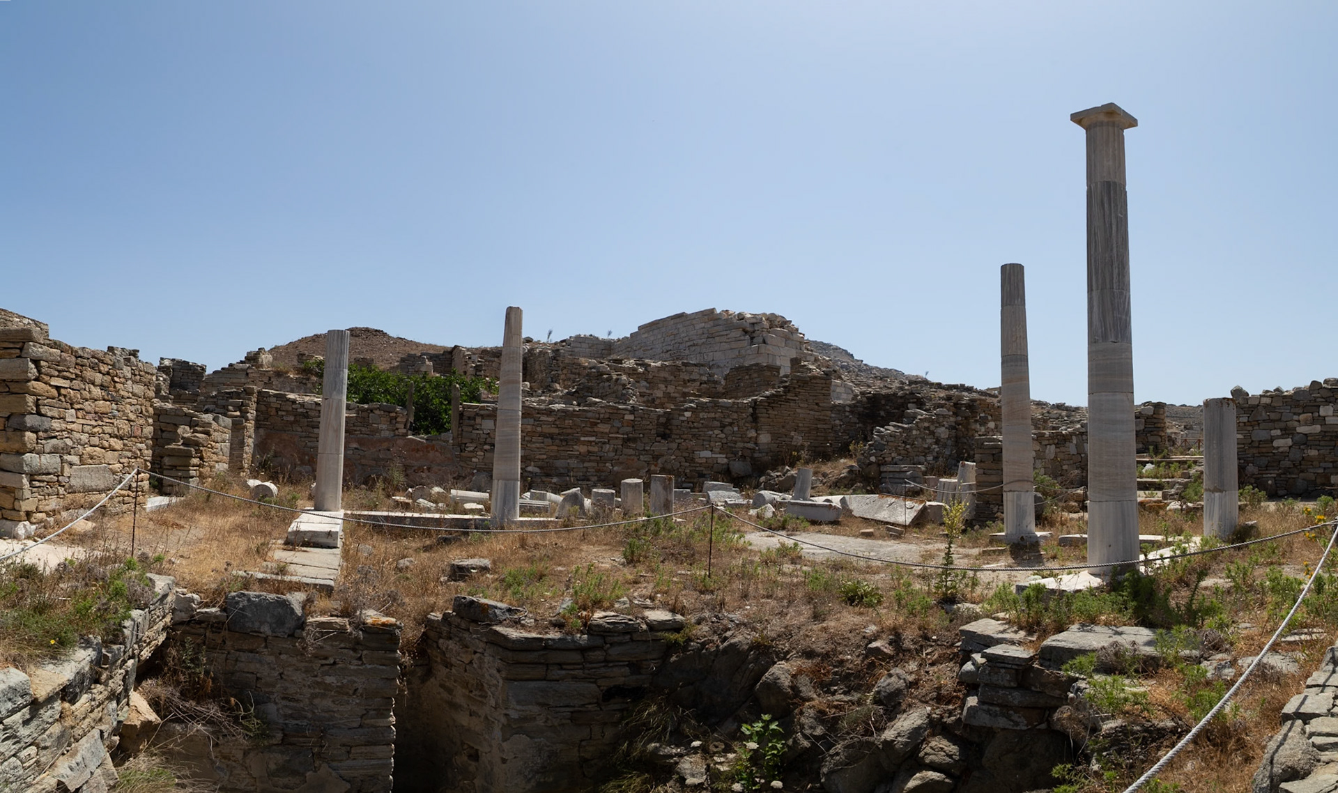 Delos, Greece - May 22nd 2018: Ruins of ancient buildings and columns stand on Delos, a Greek island and archaeological site, showcasing its rich history.