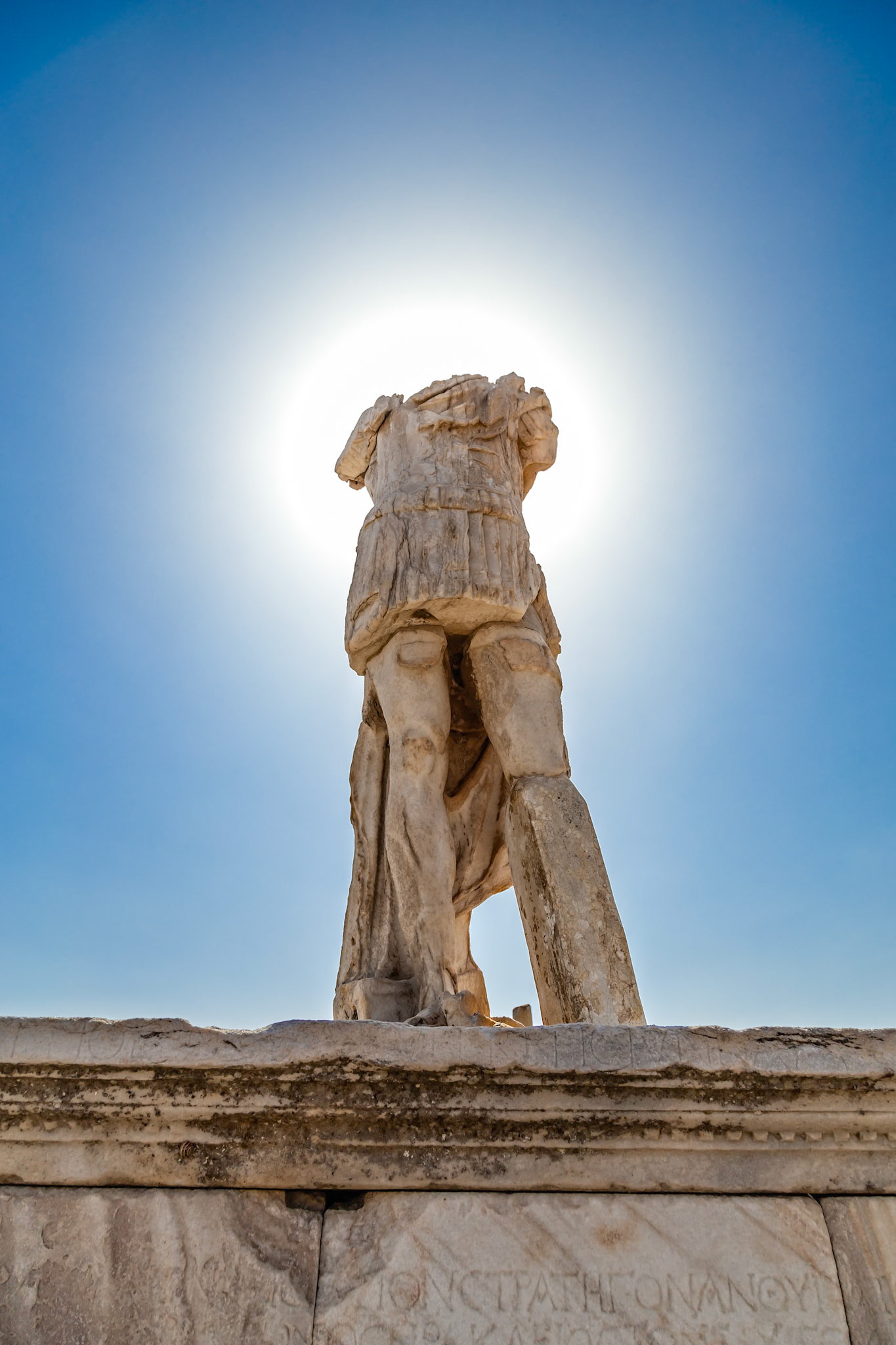 Delos, Greece - May 22nd 2018: A headless statue stands tall against the bright sun. It's a reminder of the island's rich history and cultural significance.