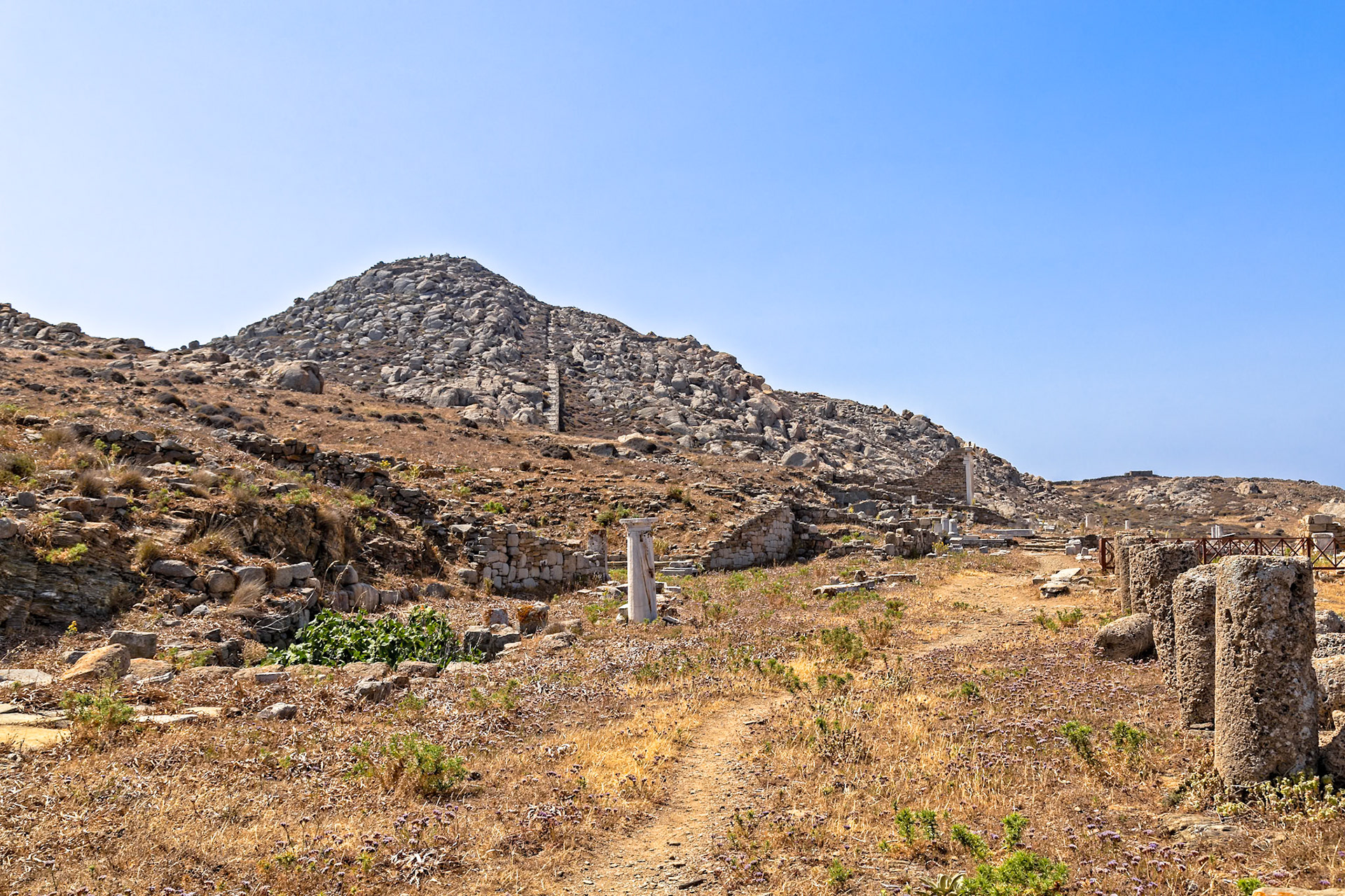 Delos, Greece - May 22nd 2018: Ruins of an ancient city on the island of Delos, Greece. The ruins include columns, walls, and other structures, showcasing the island's rich history.
