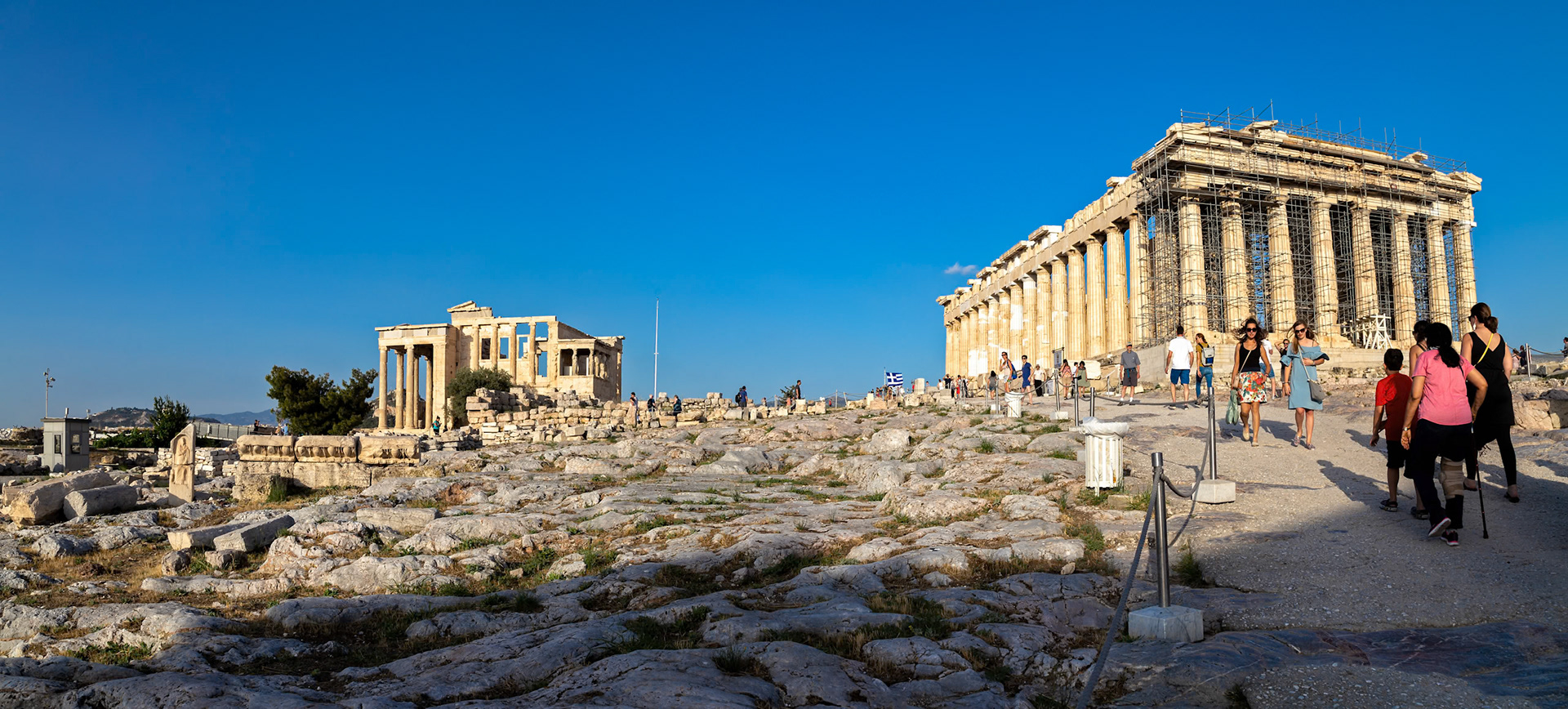 Acropolis, Athens, Greece - May 23rd 2018: Tourists explore the Acropolis, viewing the Parthenon and Erechtheion, to learn about ancient Greek history and culture.