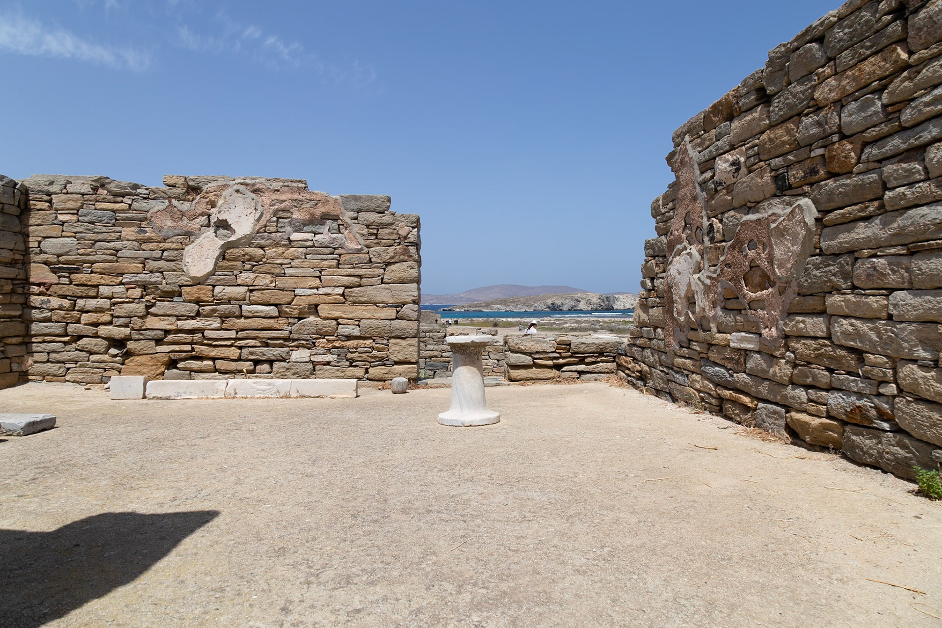 Delos, Greece - May 22nd 2018: Ruins of an ancient structure stand against a clear blue sky, showcasing the historical significance of Delos.