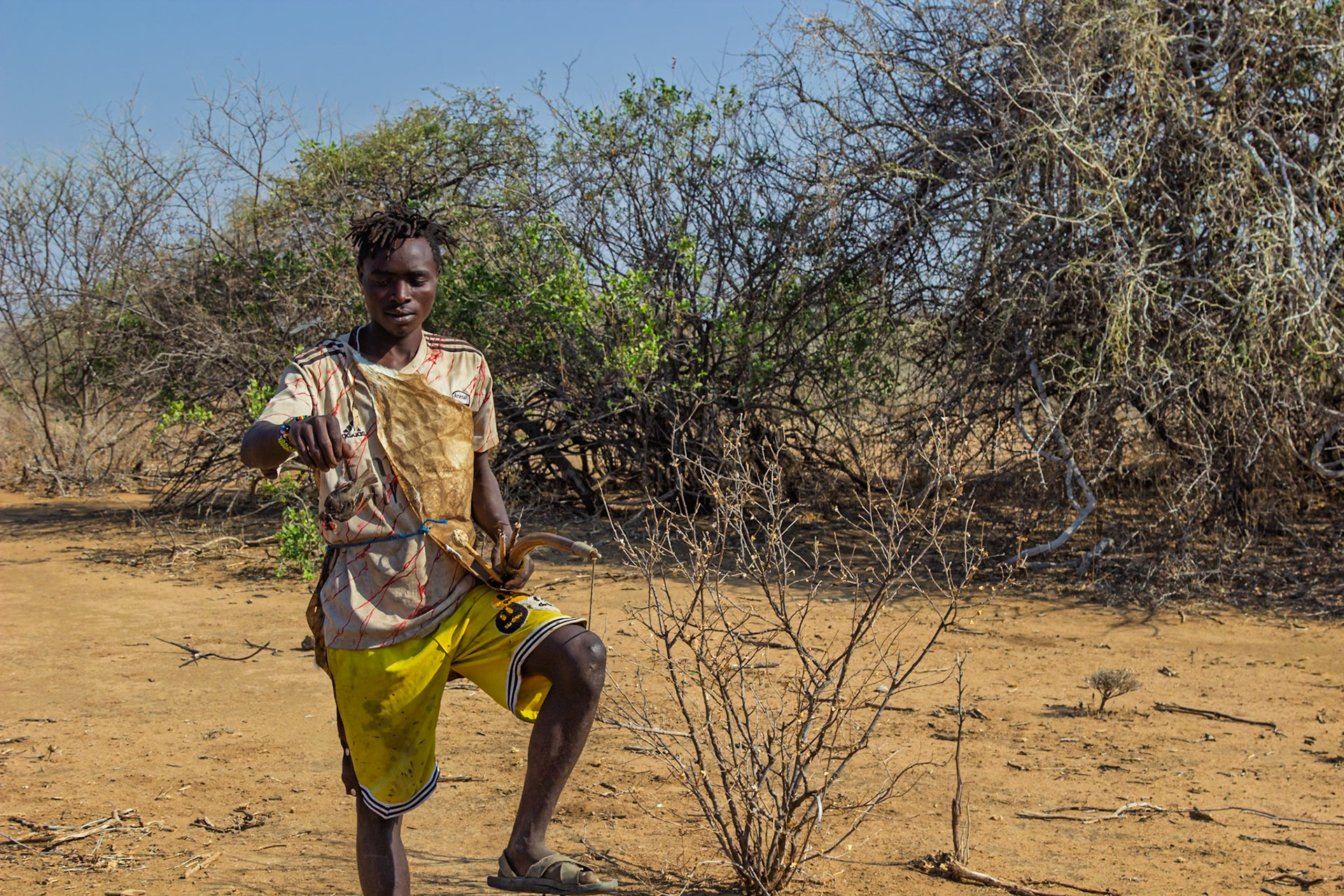 Hadzabe Tribe Camp, Tanzania - September 27th 2025: A young man displays his hunting tools, ready to provide for his community.