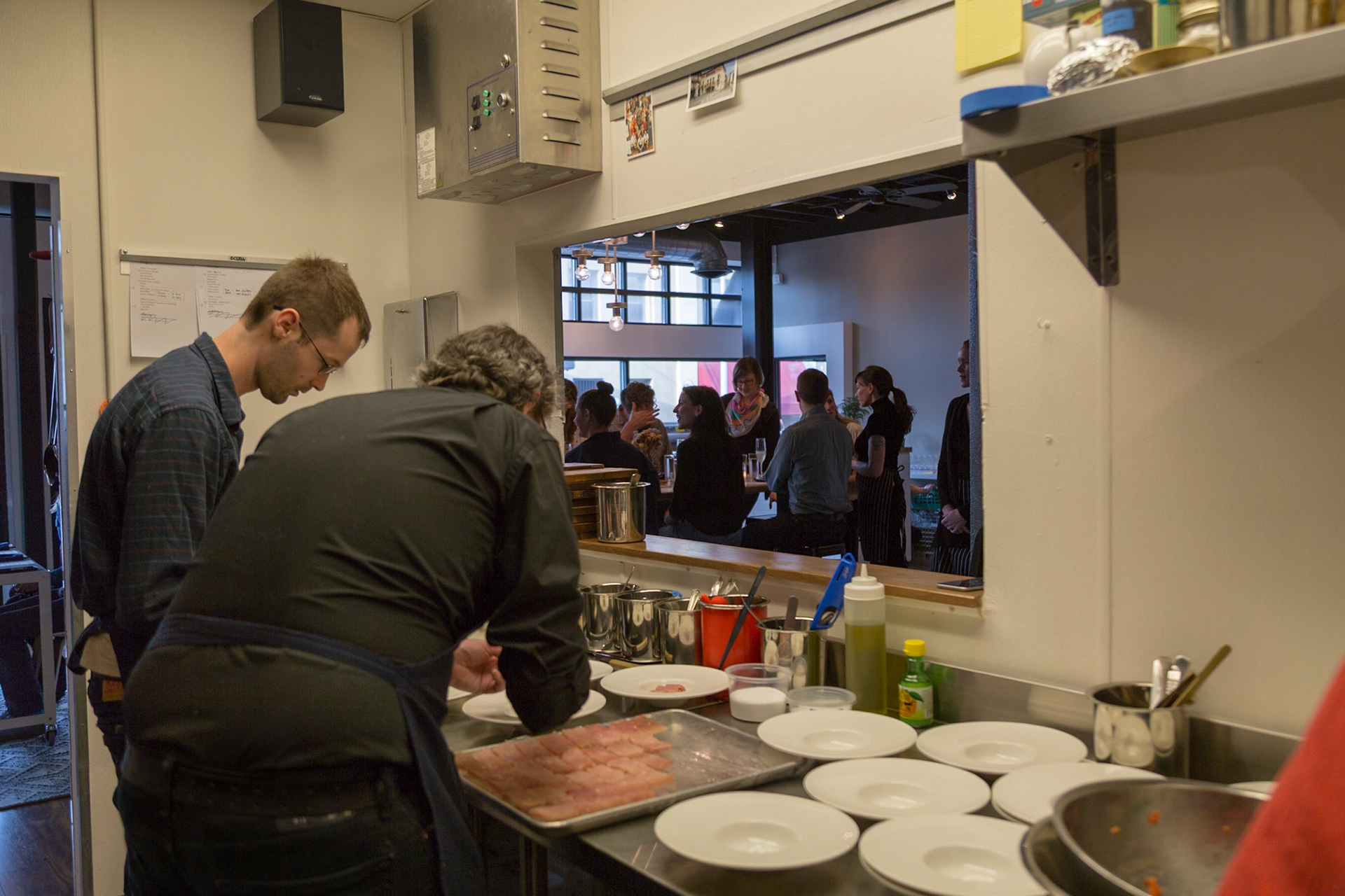 Fog Lark, Portland, Oregon - April 6th 2018: Chefs plating food in the kitchen, preparing for diners in the restaurant.