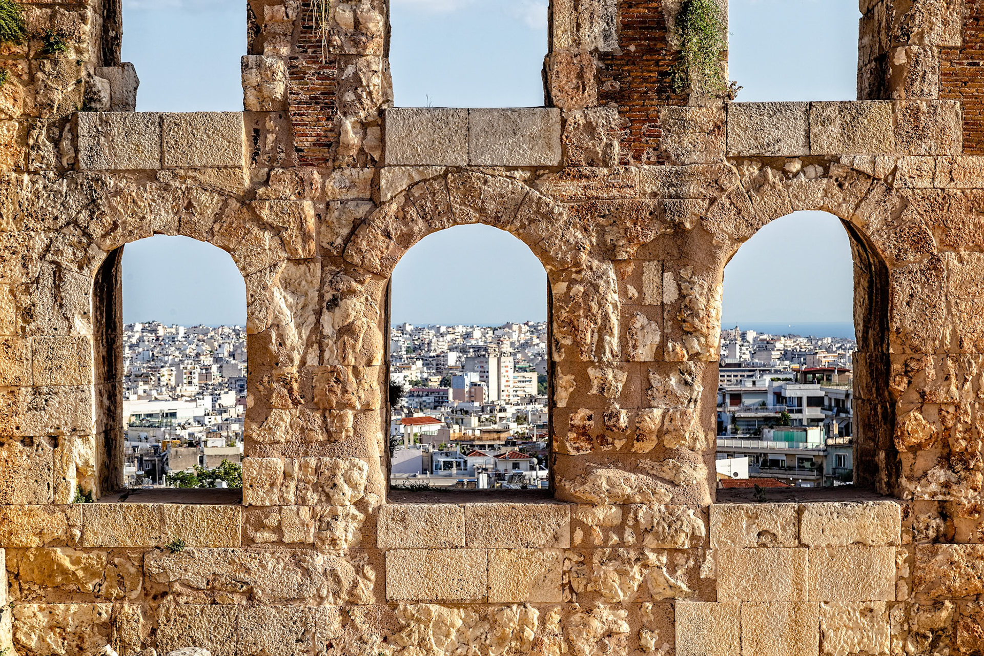 Acropolis, Athens, Greece - May 23rd 2018: A view of the city of Athens through the arches of the Odeon of Herodes Atticus, a Roman theater.
