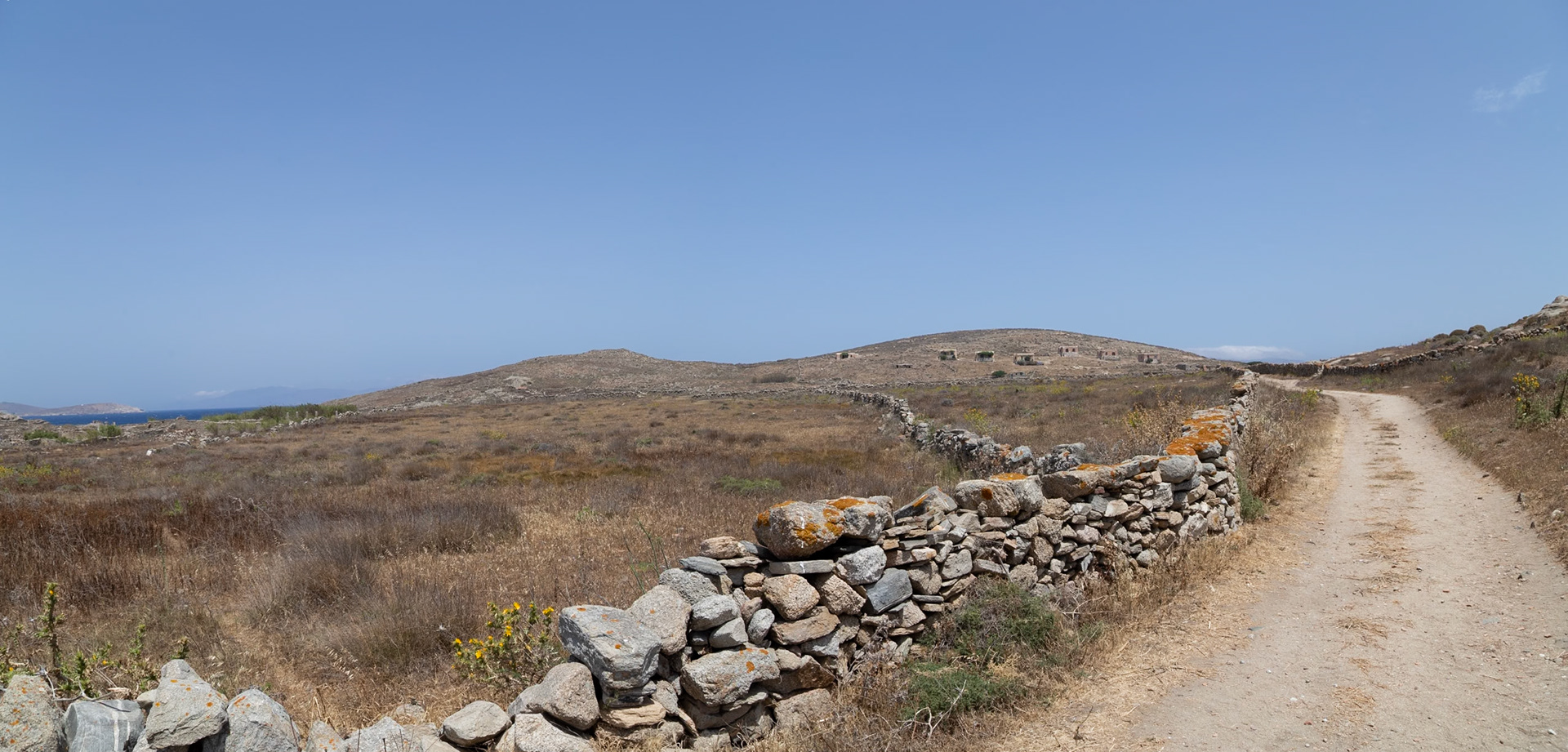 Delos, Greece - May 22nd 2018: A dirt path winds through the ancient ruins of Delos, a UNESCO World Heritage site, offering a glimpse into the island's rich history.