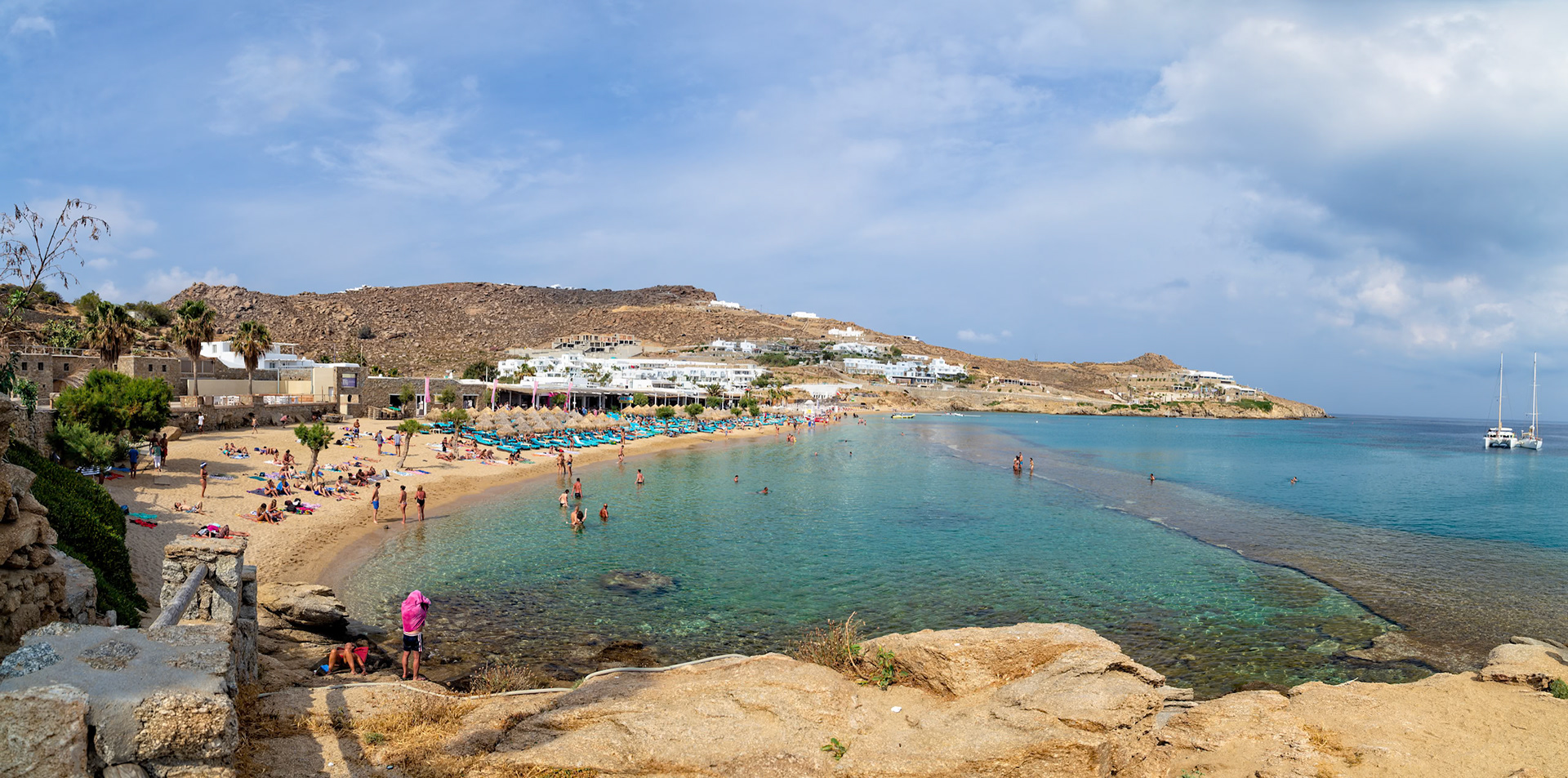 Paradise Beach, Mykonos, Greece - May 24th 2018: People enjoy swimming and sunbathing on a sunny day at the popular beach destination.