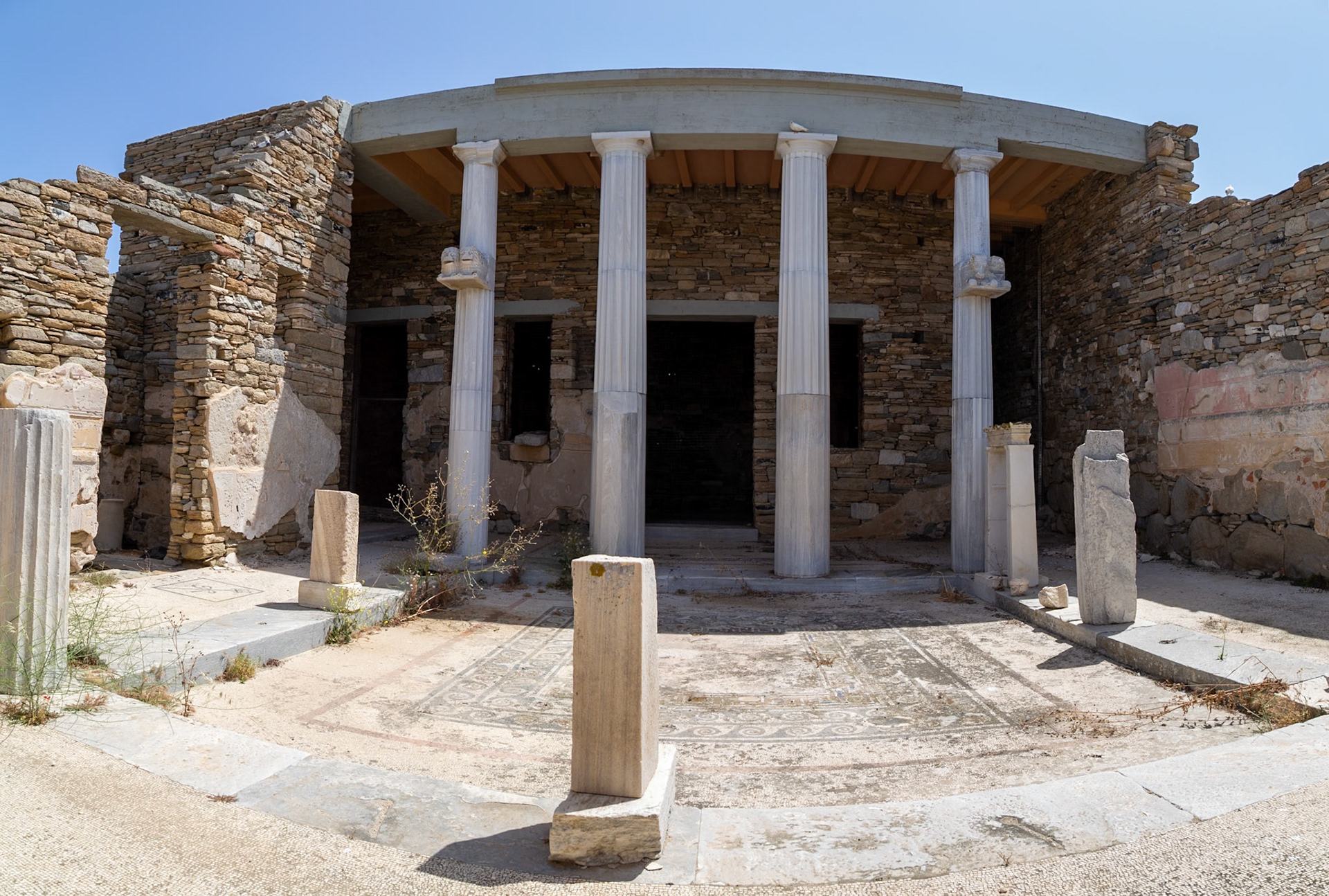 Delos, Greece - May 22nd 2018: Ruins of an ancient building with columns and mosaic floor. This is a historical site, preserved for its cultural significance.