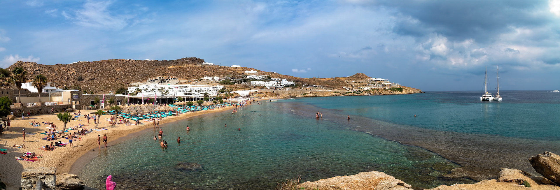 Paradise Beach, Mykonos, Greece - May 24th 2018: People enjoy swimming and sunbathing on a sunny day at the popular beach resort.