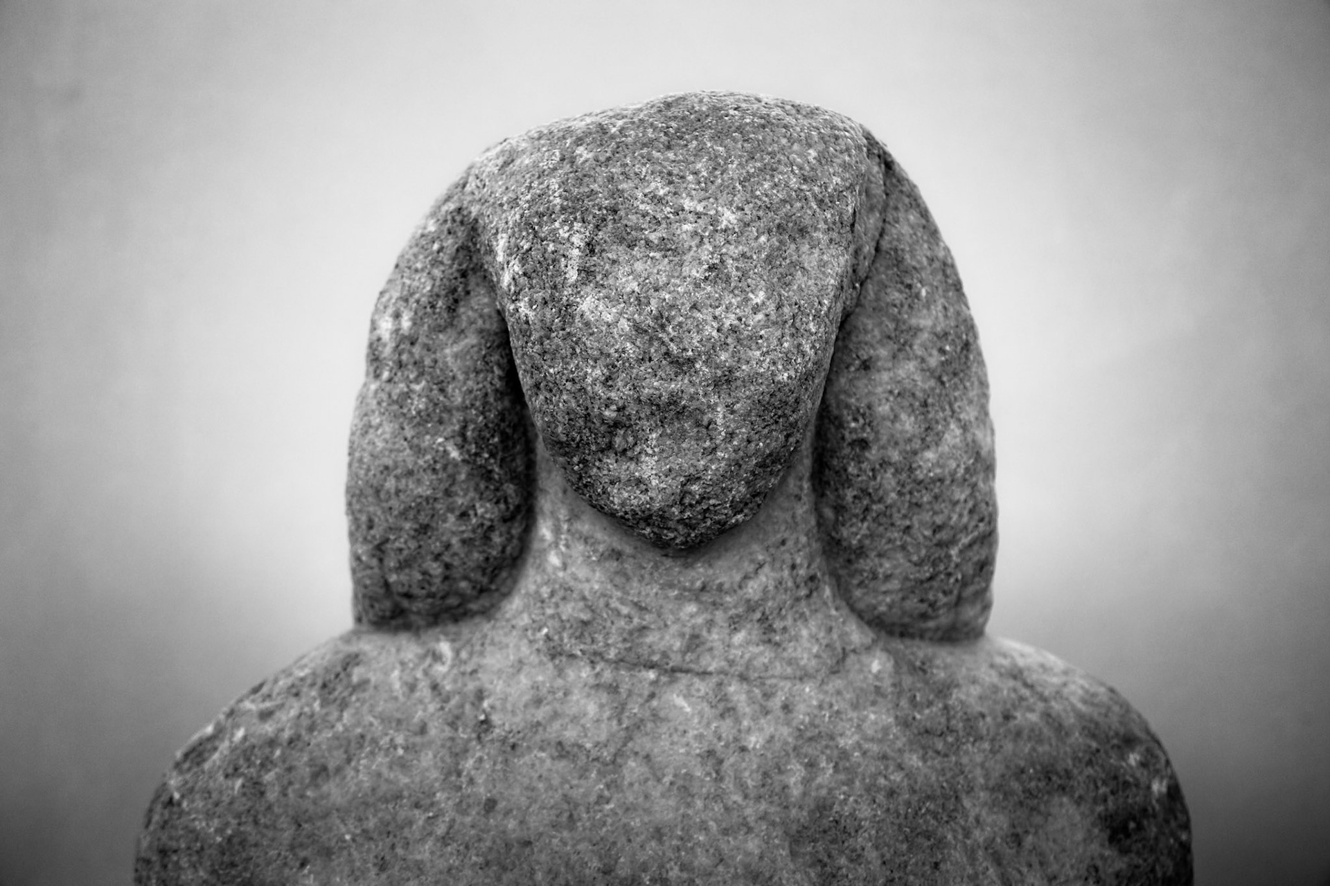 Delos, Greece - May 22nd 2018: A weathered, headless statue stands as a testament to ancient artistry, its form eroded by time yet still evocative.