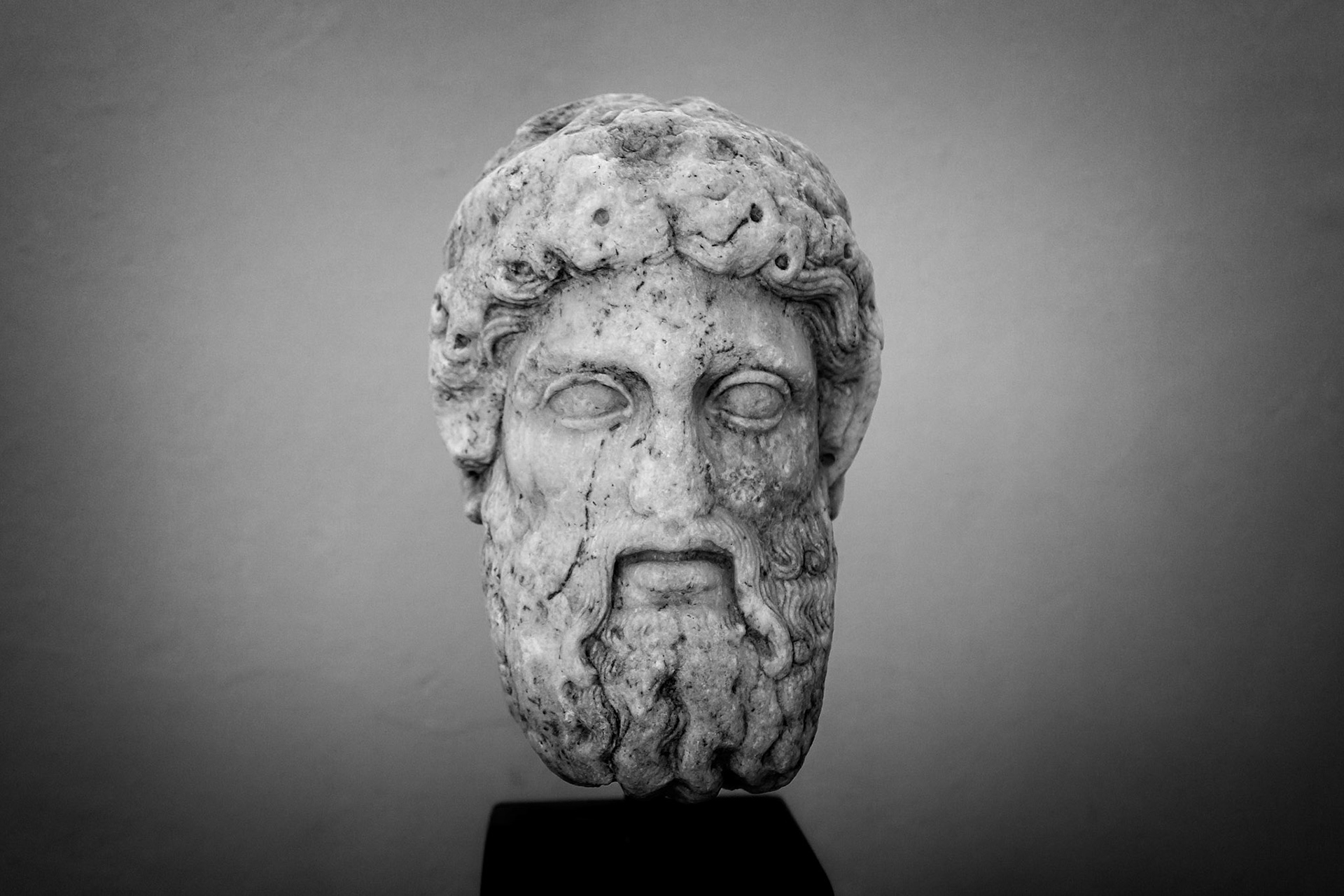 Delos, Greece - May 22nd 2018: A marble head of a bearded man, possibly a god or philosopher, is displayed. It's an artifact showcasing ancient Greek sculpture.