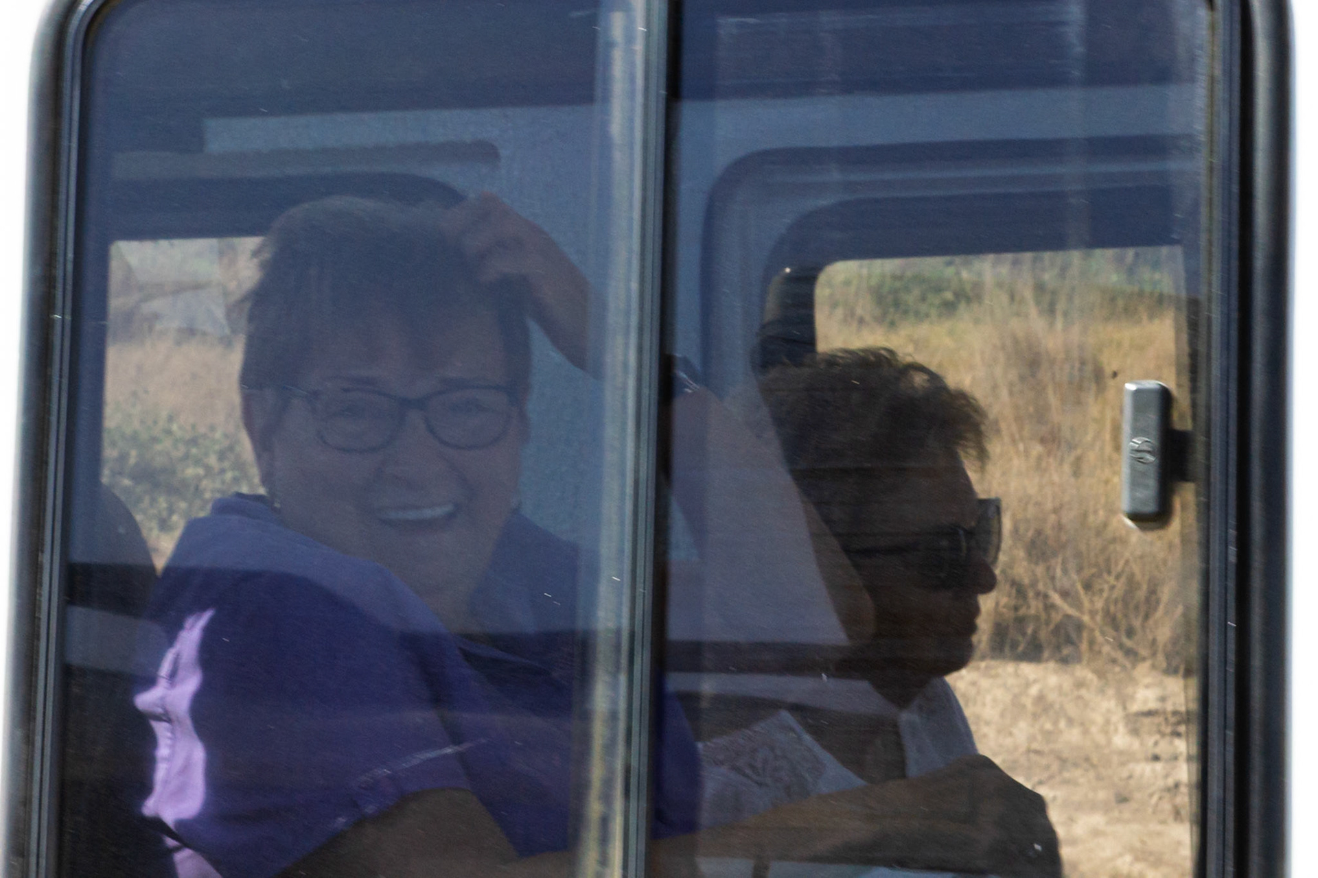 Tourists in Amboseli National Park, Kenya, enjoy a safari, viewing wildlife from the safety of their vehicle.