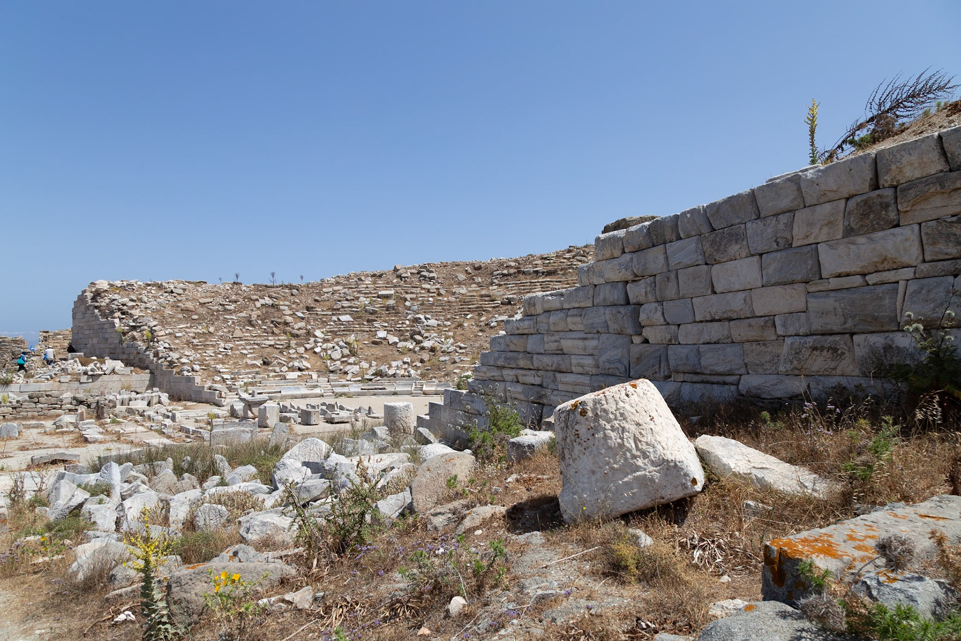Delos, Greece - May 22nd 2018: Ruins of an ancient structure stand against a clear sky. The site is a popular tourist destination for history enthusiasts.