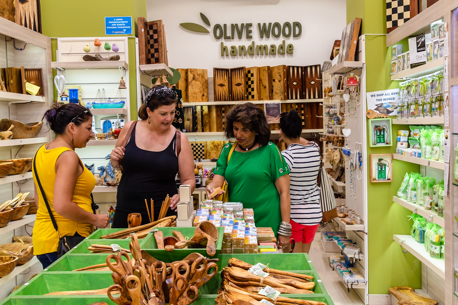 Athens, Greece - May 23rd 2018: Shoppers browse handmade olive wood items and soaps at a local shop, seeking unique souvenirs and gifts.