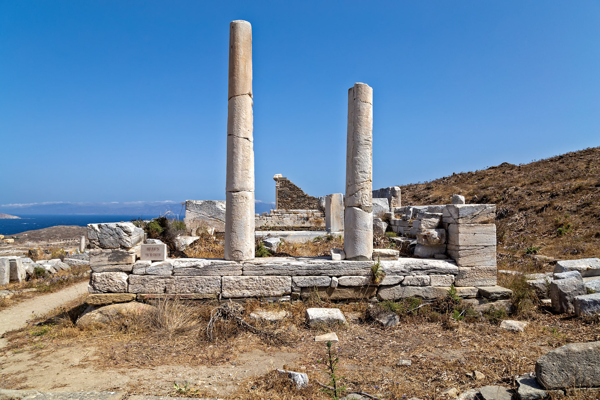 Delos, Greece - May 22nd 2018: Ruins of the Temple of Hera, also known as the Heraion, stand on the island of Delos, Greece. The temple was dedicated to the goddess Hera.